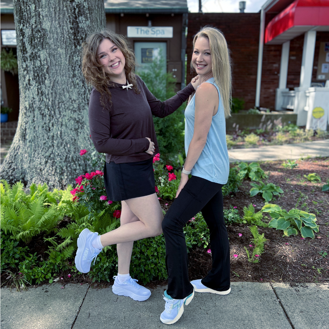two women smiling in Vuori apparel and sneakers from HOKA and Diadora