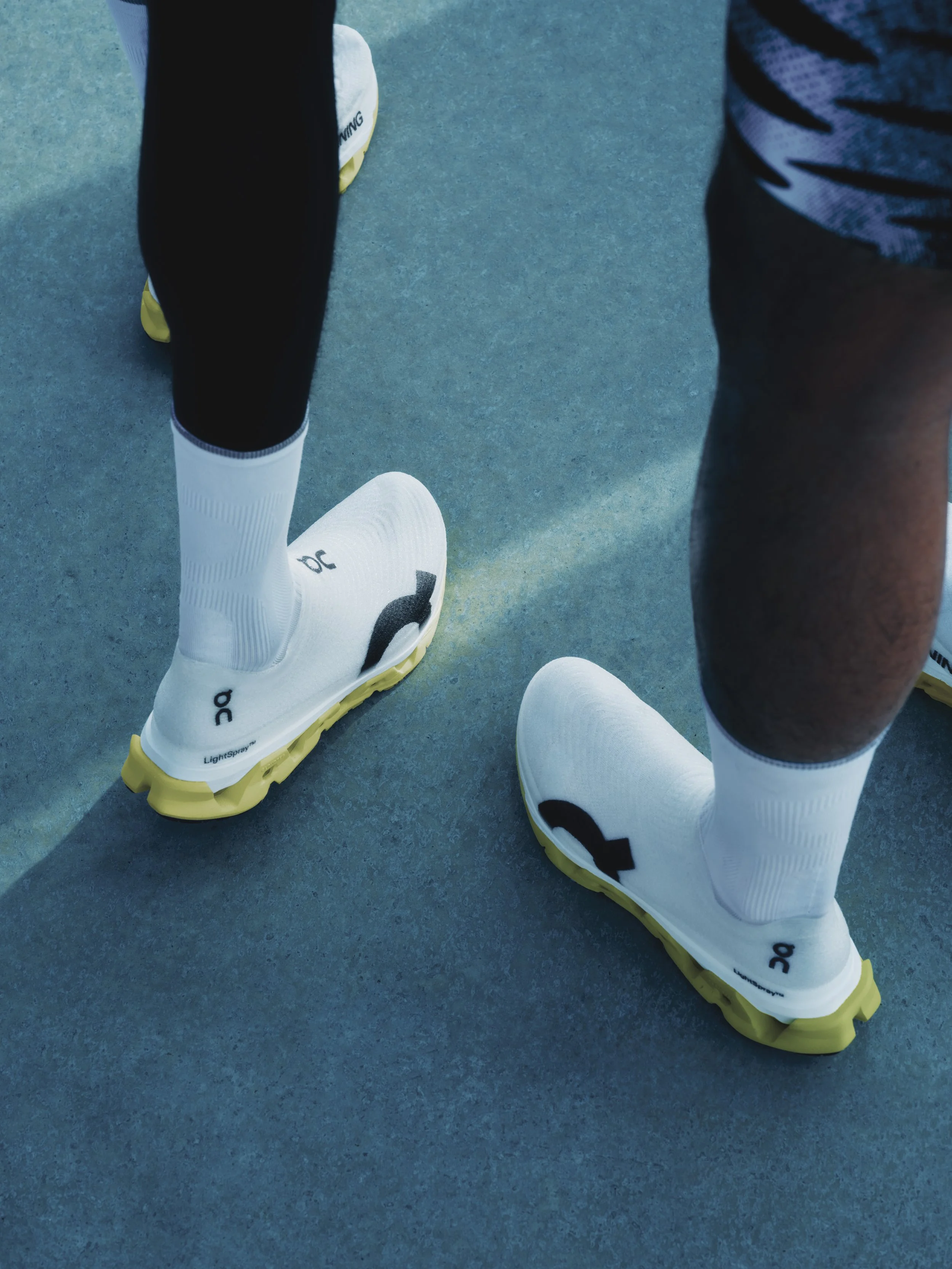 Closeup of people wearing Closeup of On LightSpray Cloudmonster 3 Hyper running shoes