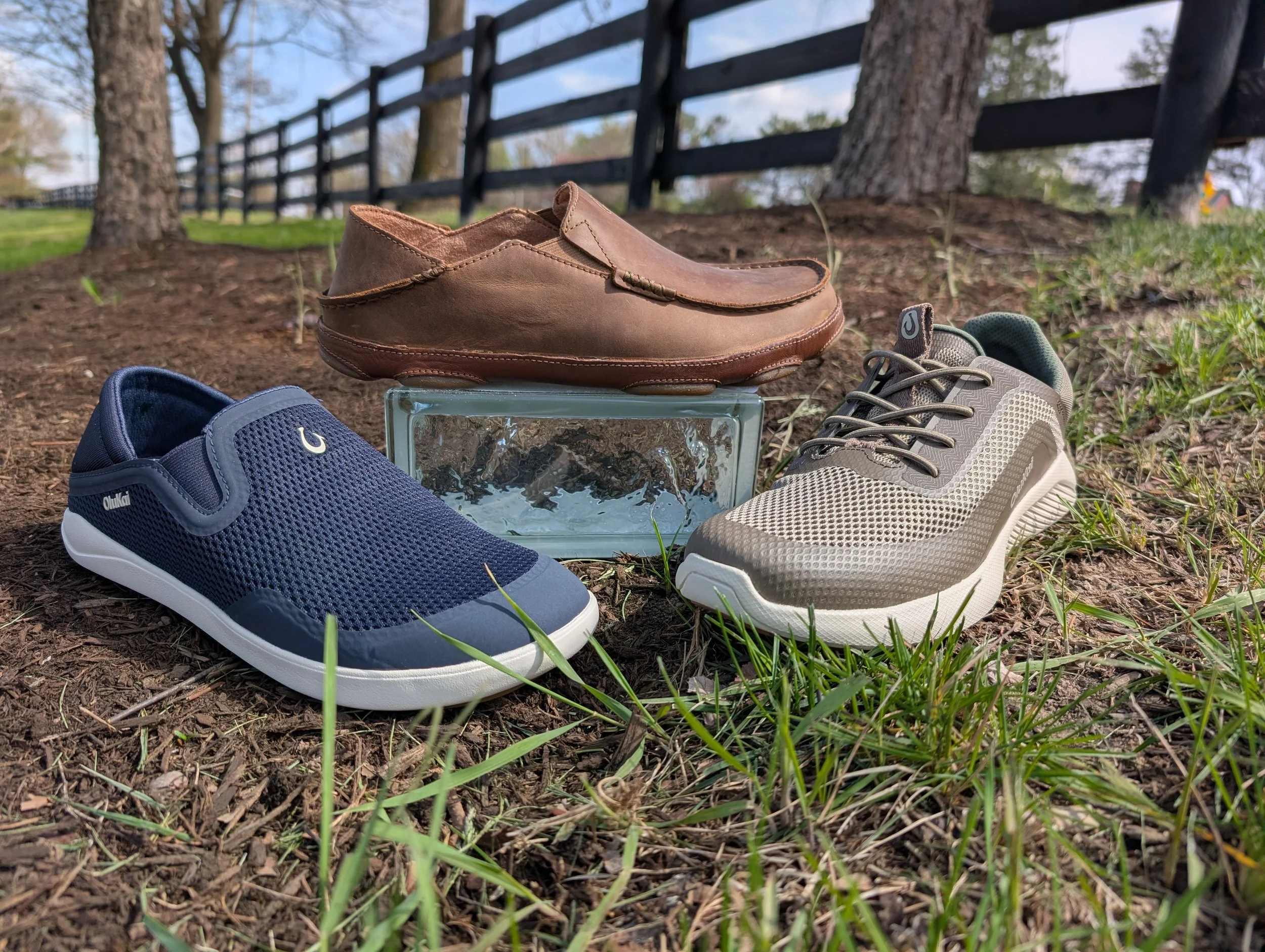 men's OluKai shoes placed outside a picket fence