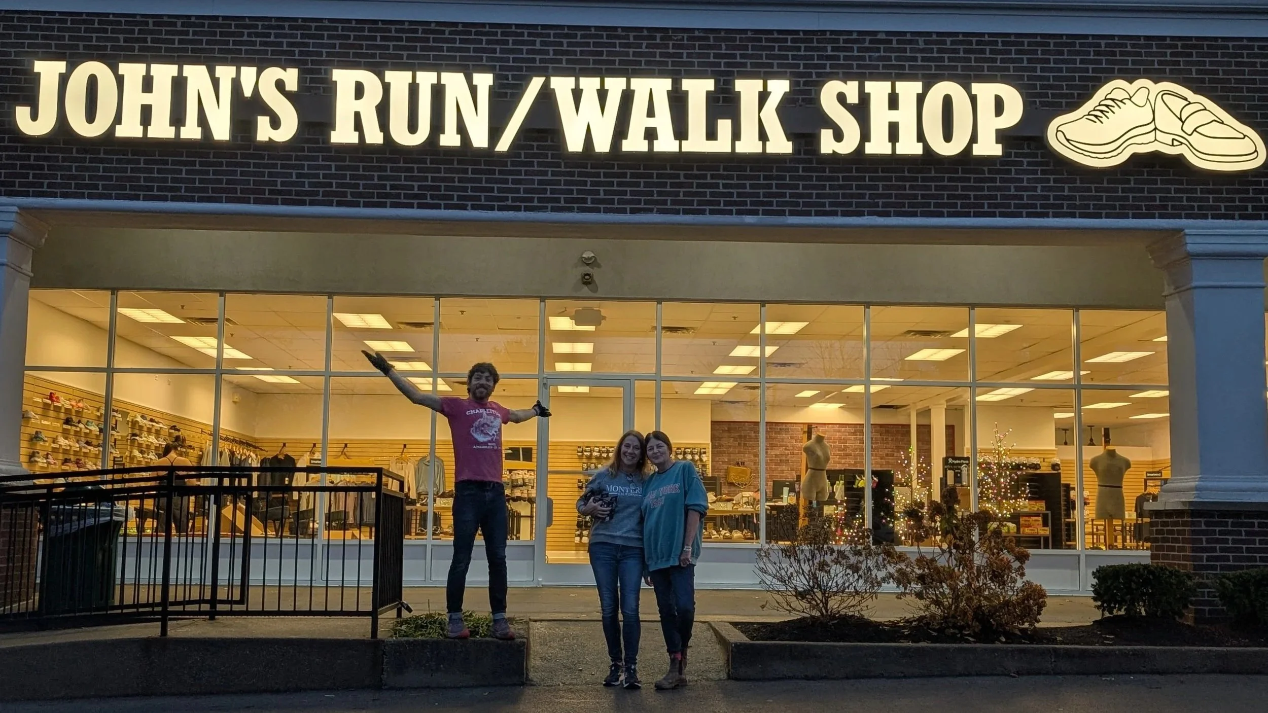 Staff in front of John's Run/Walk Shop in Hamburg at night