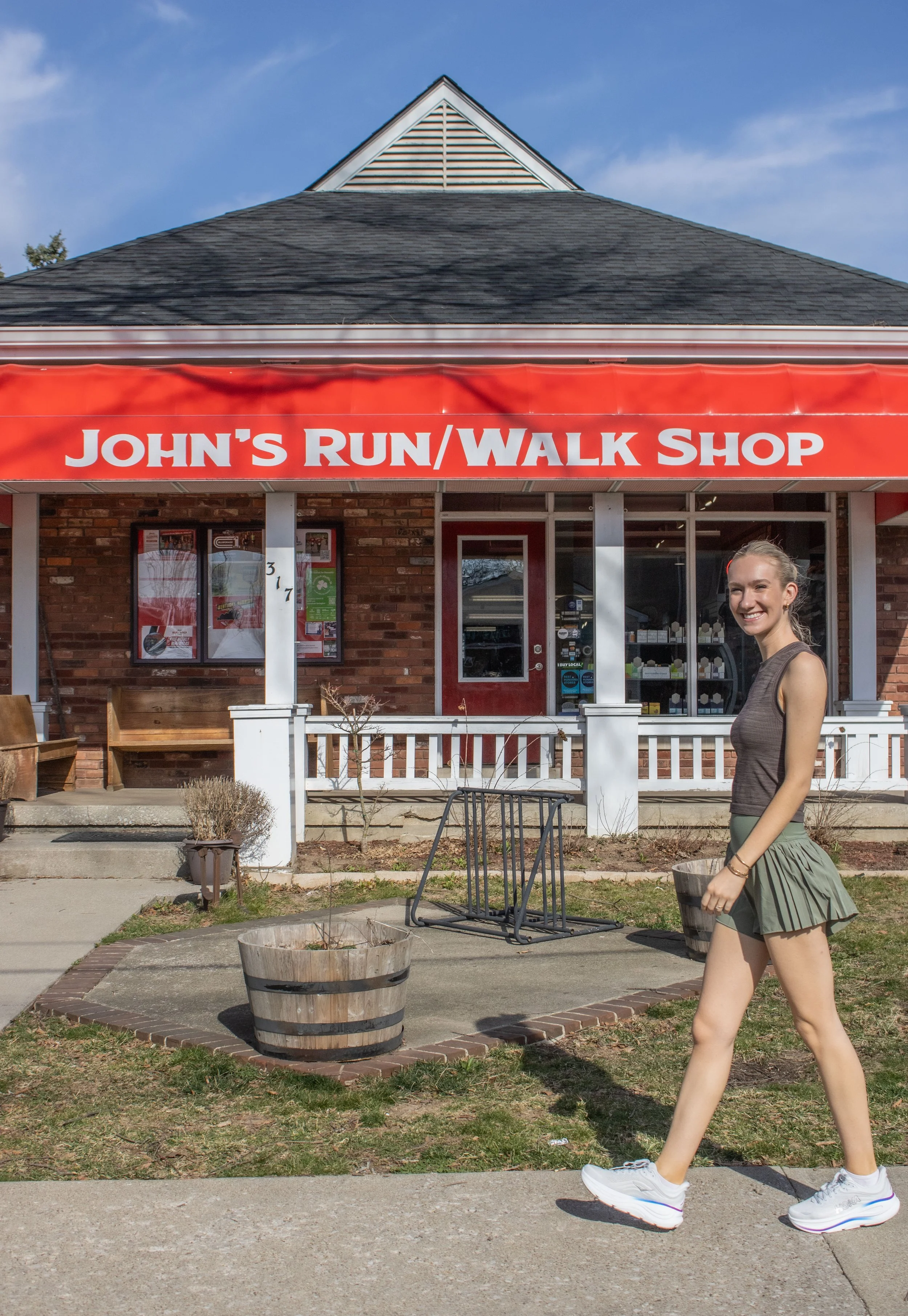 woman in HOKA Bondi 9 walking past John's Run/Walk Shop in Lexington, Ky