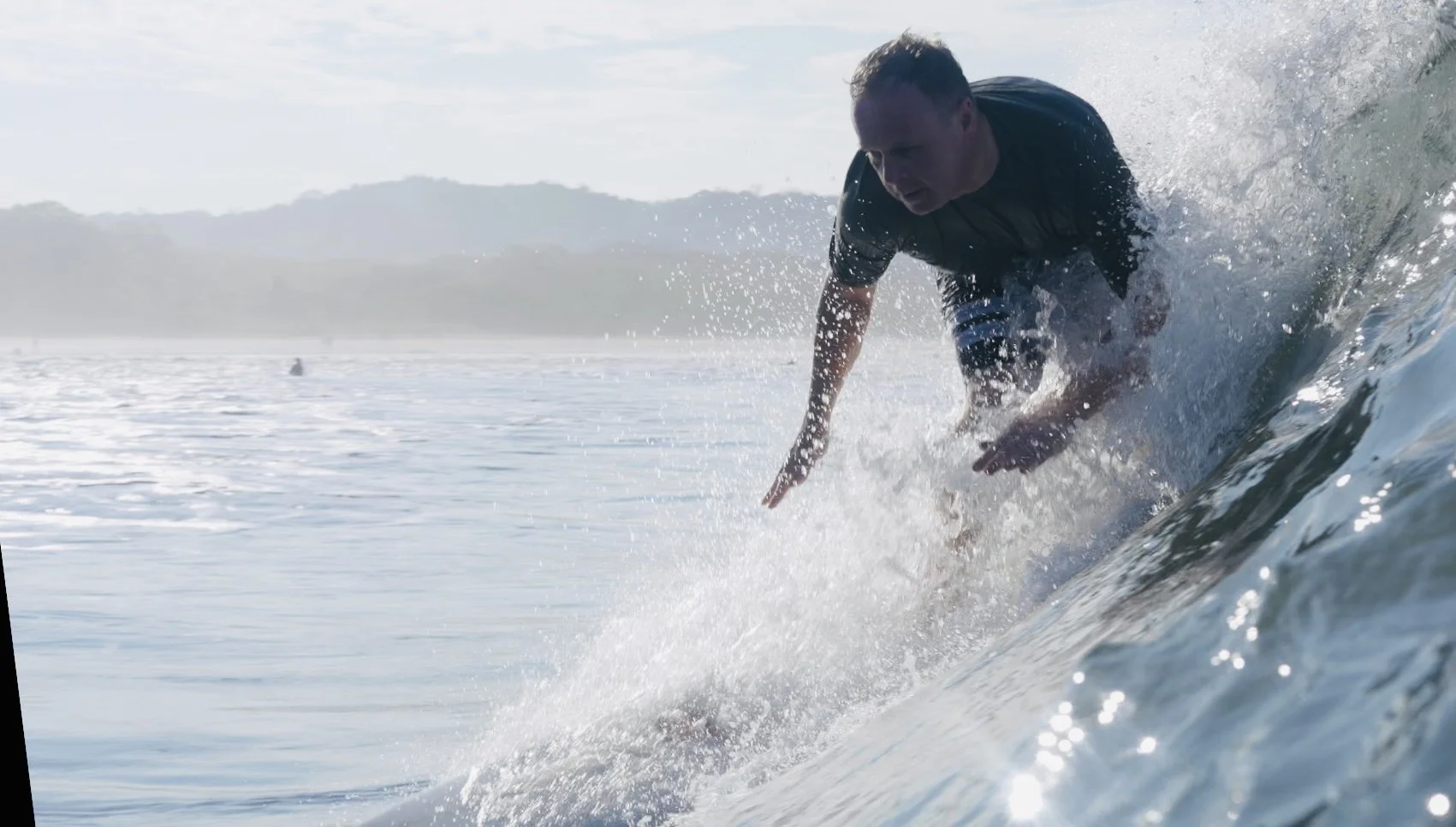 A man surfing on a wave in the ocean during daytime.