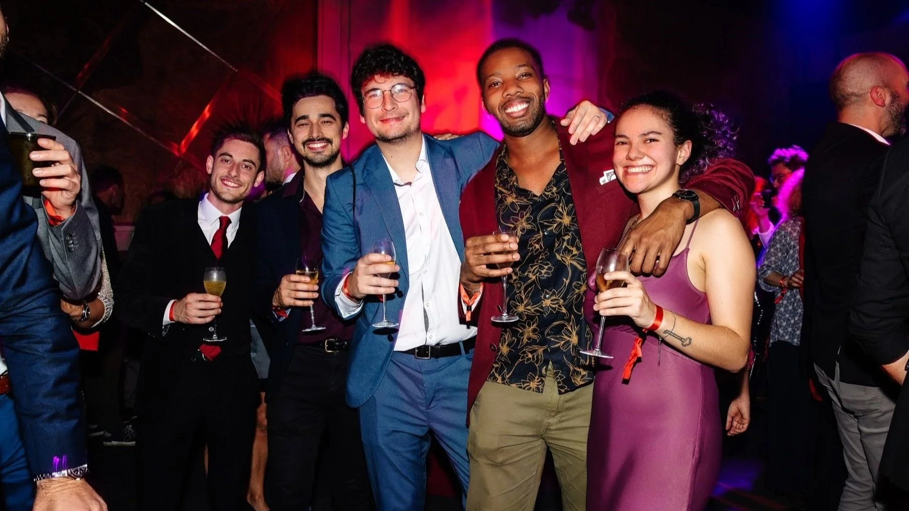 Groupe de participants posant avec boissons lors d’une soirée corporate festive.