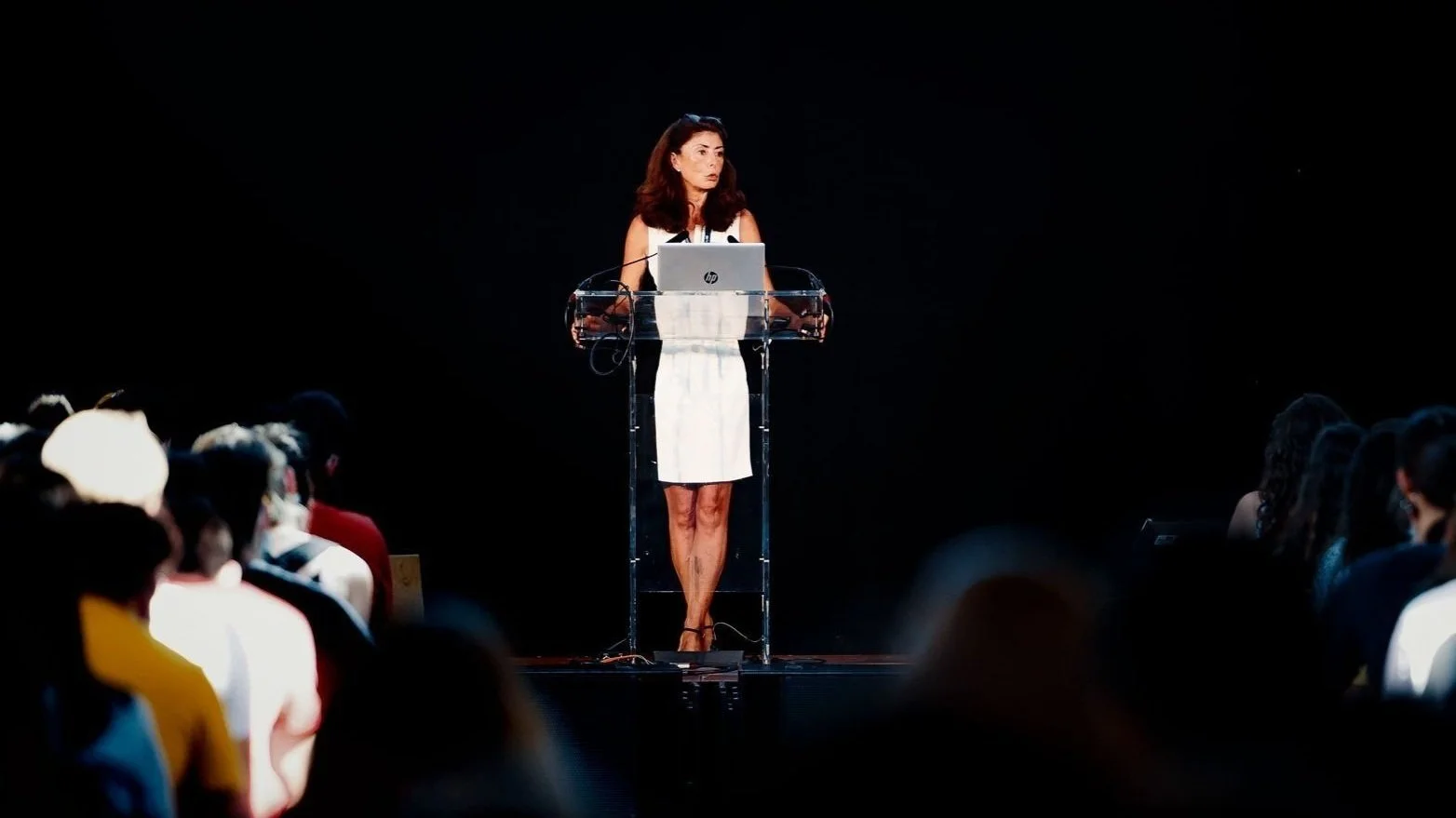 Présentation d’une intervenante sur scène devant un public lors d’une conférence professionnelle.