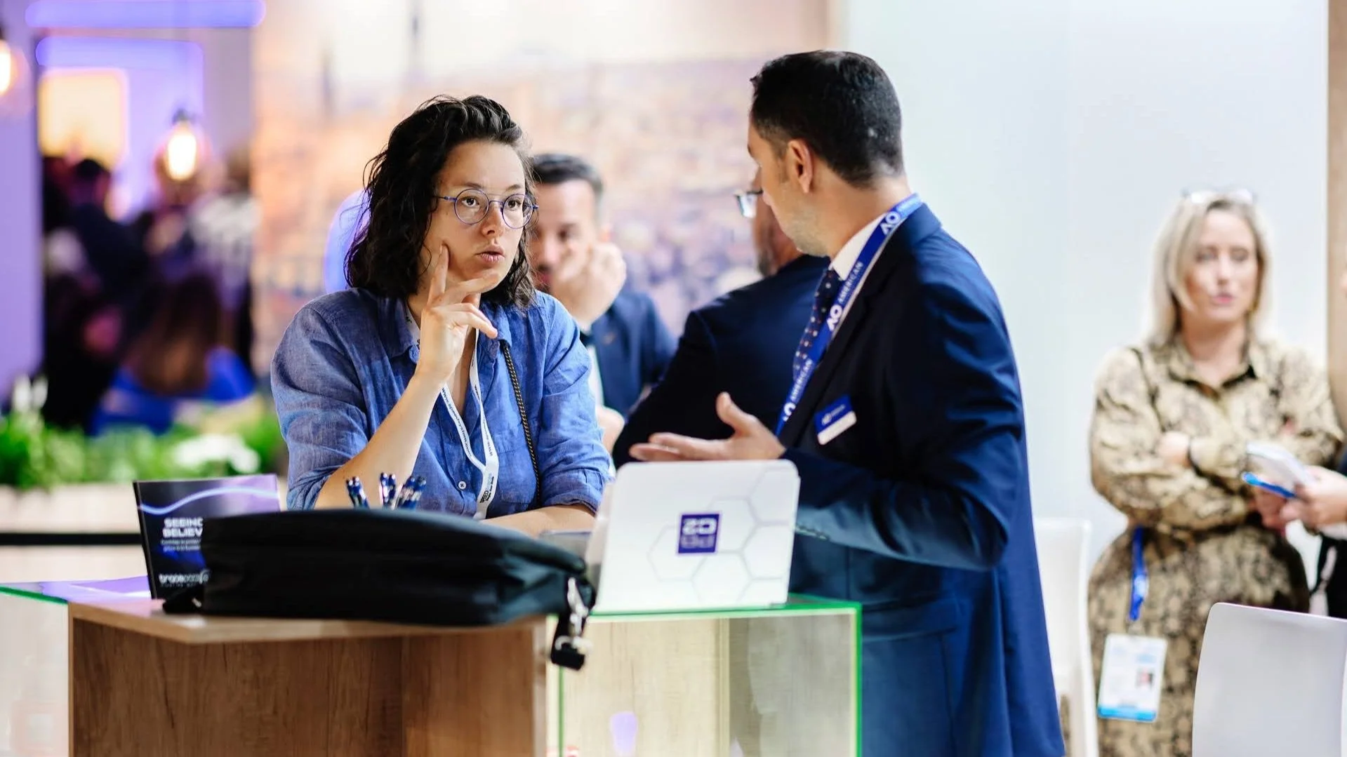 Discussion professionnelle entre collaborateurs sur un stand lors d’un salon B2B.