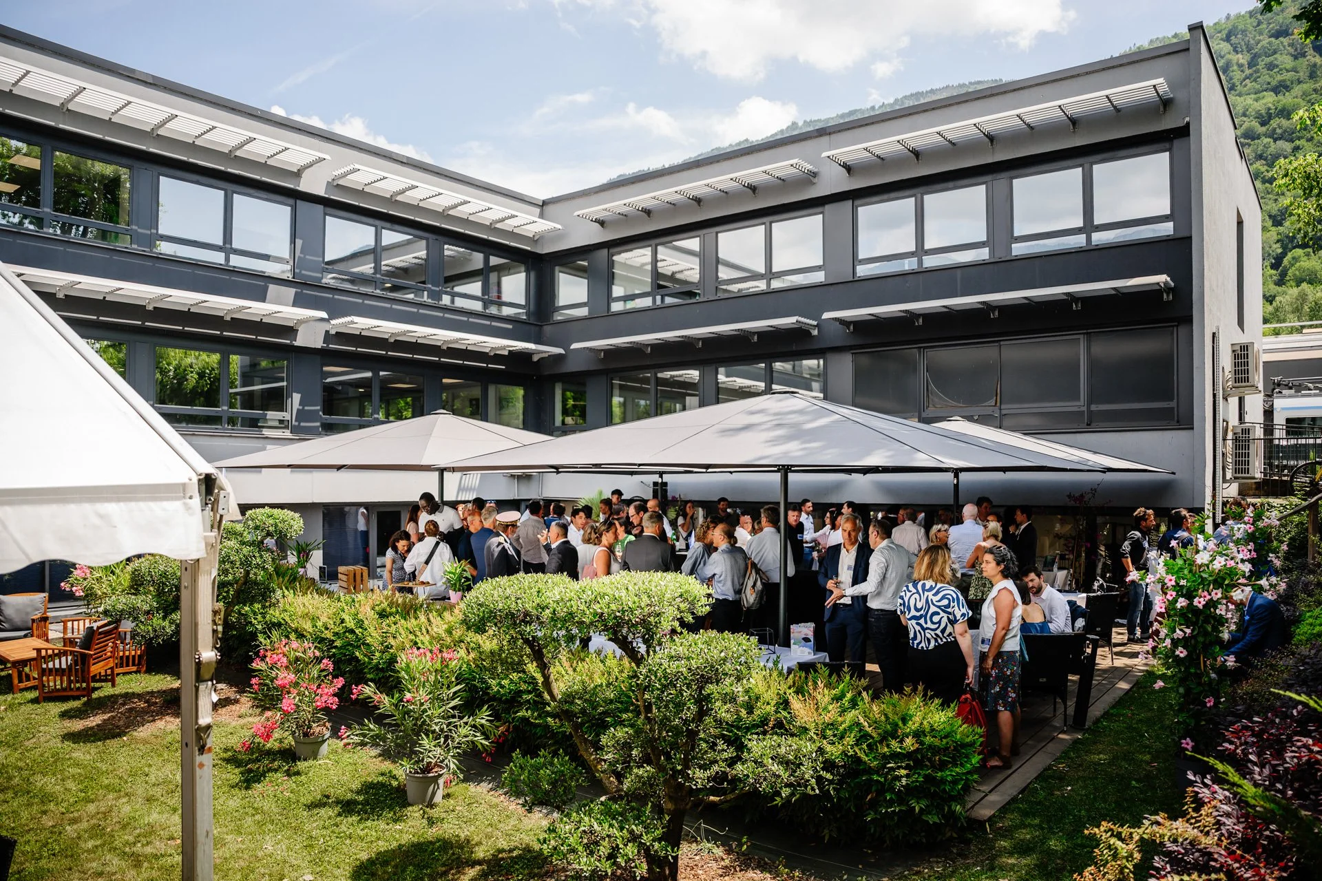 Vue d’ensemble du cocktail rassemblant les invités dans les jardins du siège d’Heliup.