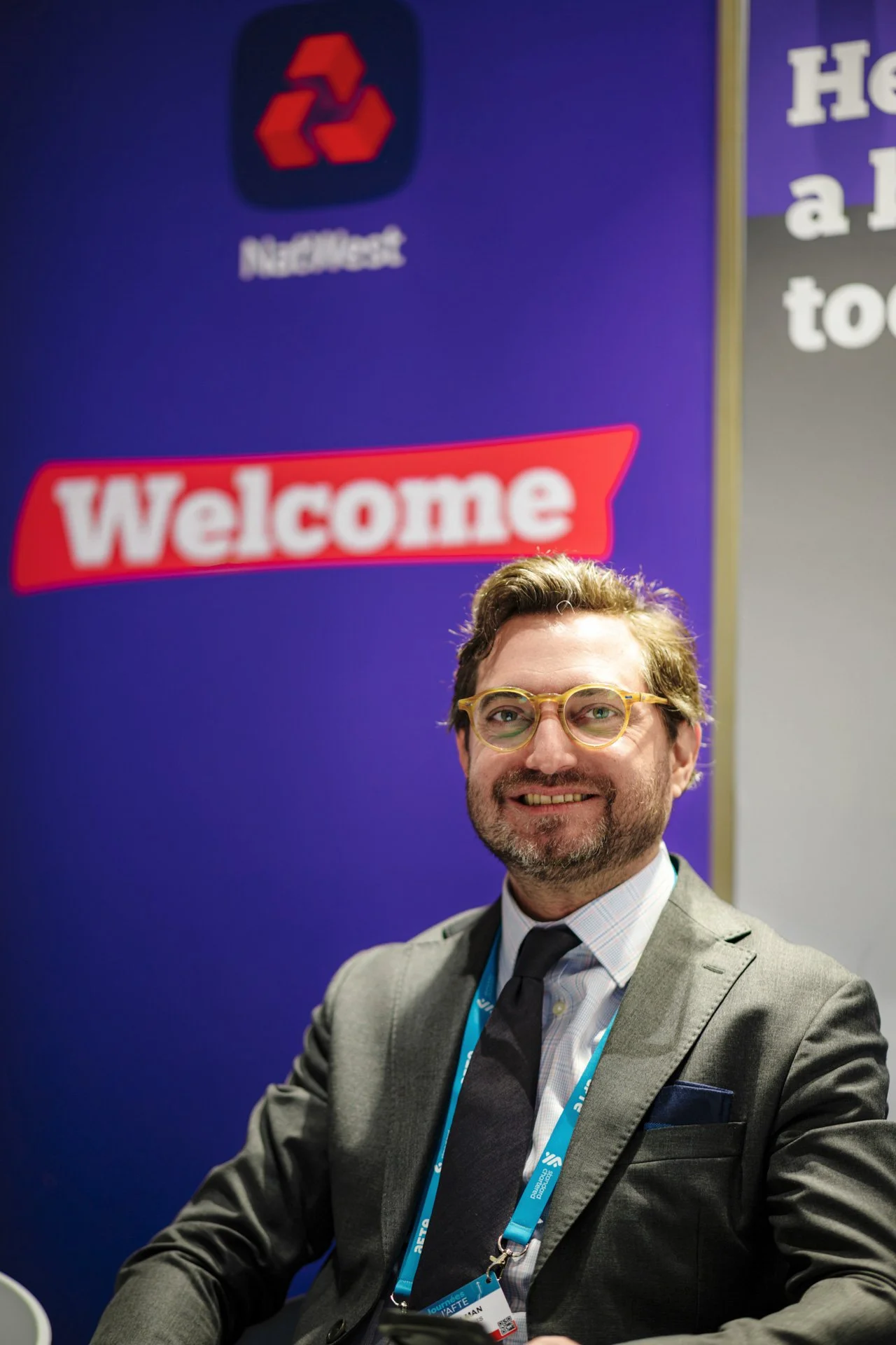 Représentant NatWest souriant, photographié sur le stand de la banque lors des Journées de l’AFTE 2025.