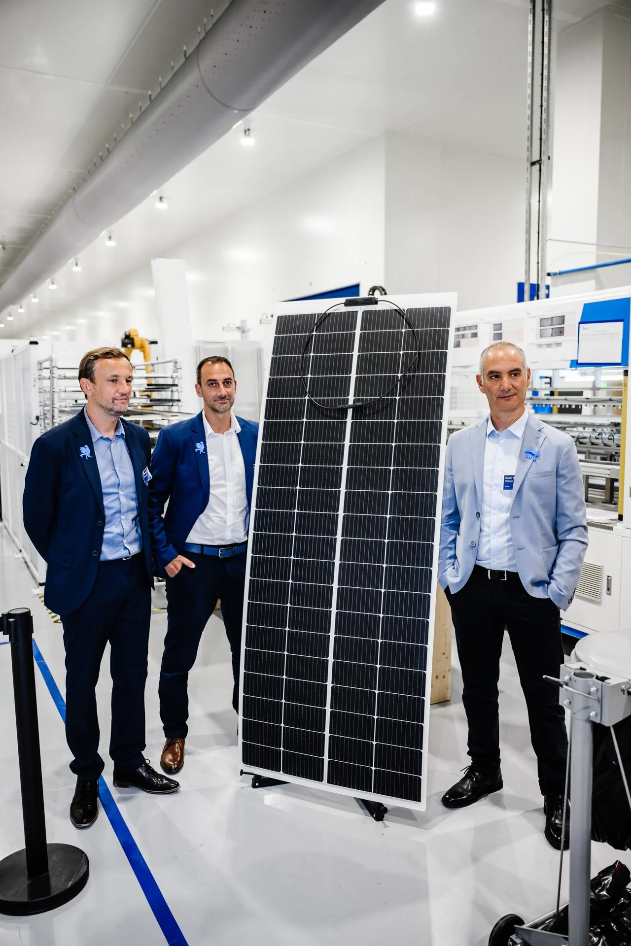 Dirigeants Heliup présentant un panneau photovoltaïque dans la nouvelle salle de production.