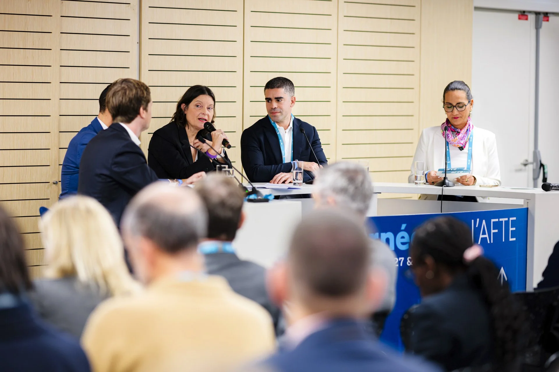 Panel d'experts sur scène pendant une conférence corporate