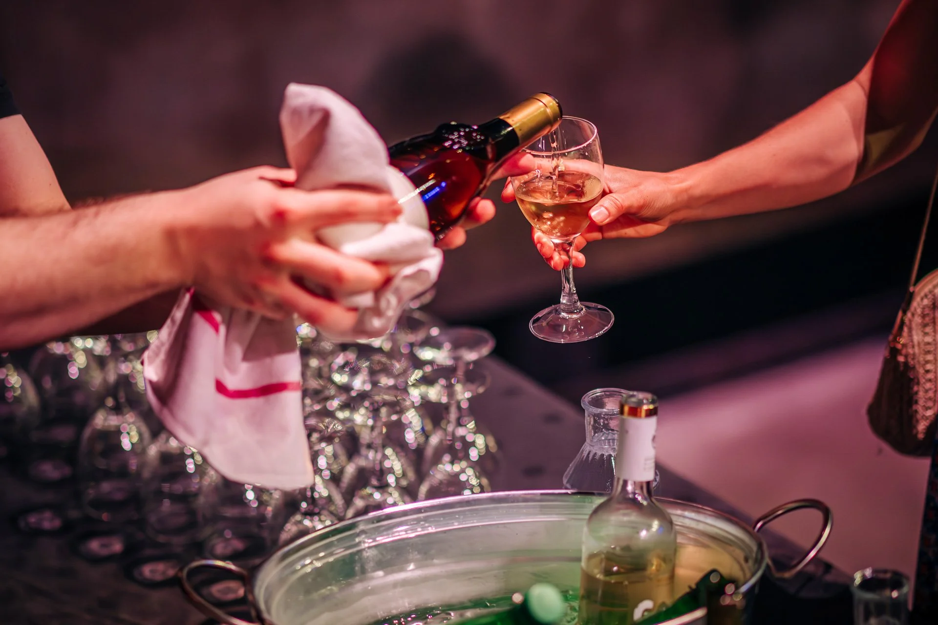 Serveur versant un verre de vin blanc lors du cocktail de l’événement CBH Graduate School à Grenoble.