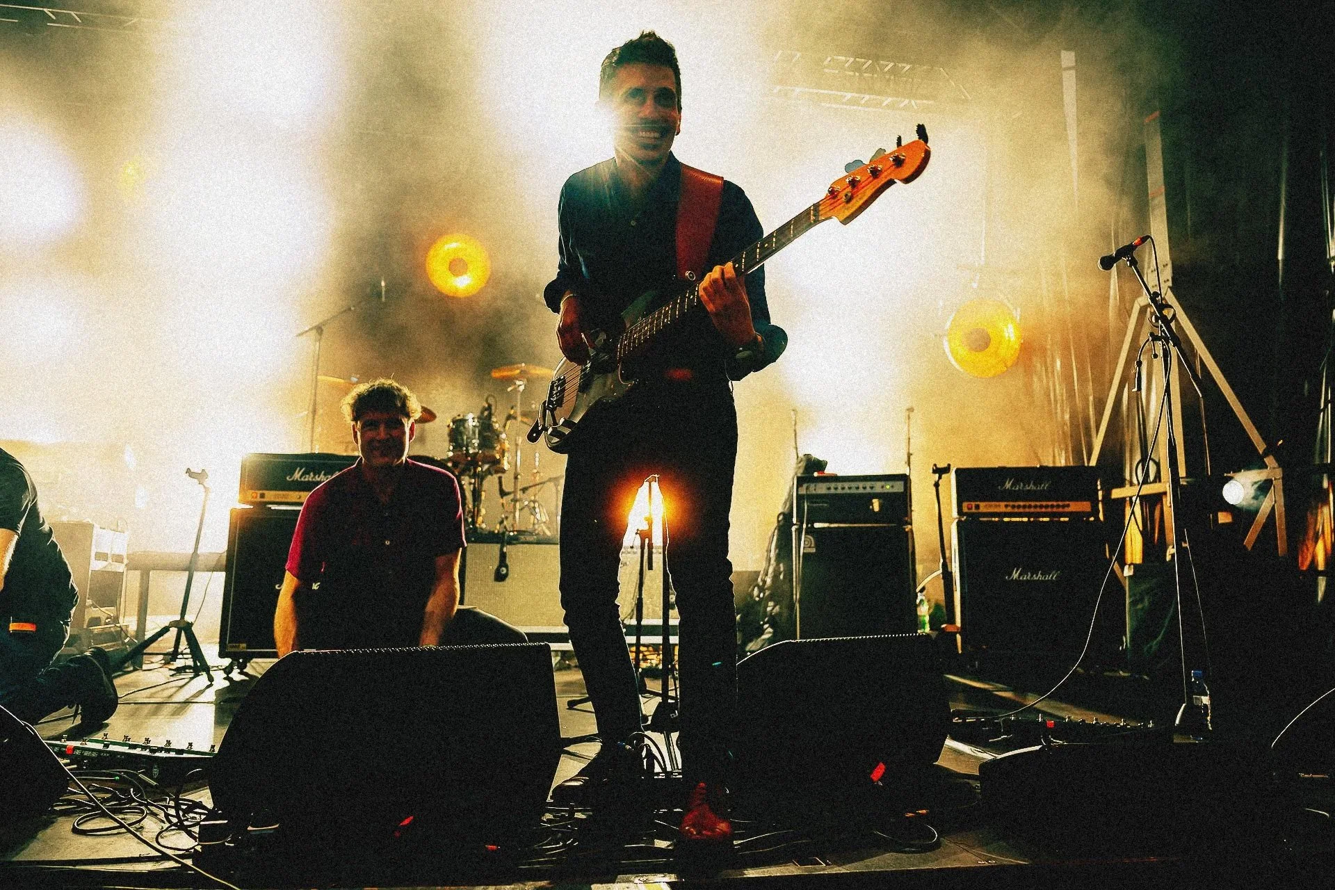 Bassiste sur scène lors d’un concert à Grenoble, énergie du jeu et puissance de la lumière captées en photo live.