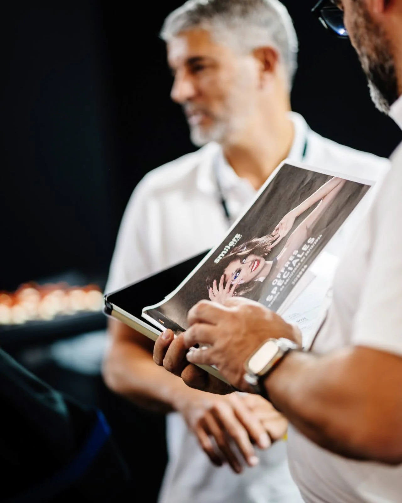 Mains tenant une plaquette d’information lors d’un événement professionnel.