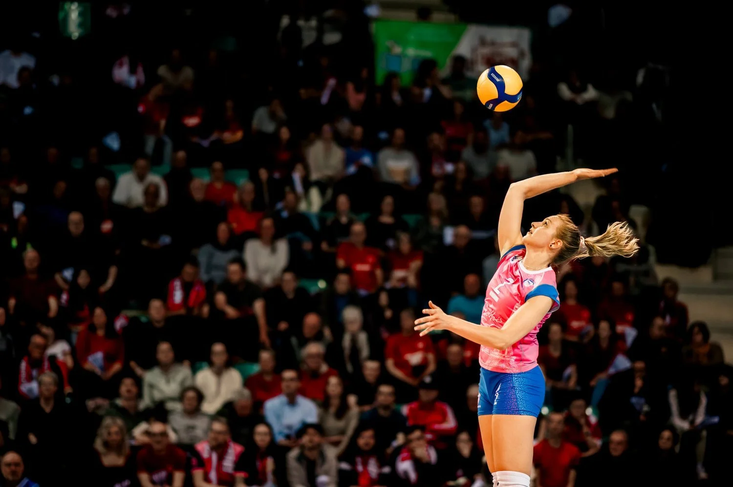 Joueuse de volley en action réalisant un service durant un match professionnel.