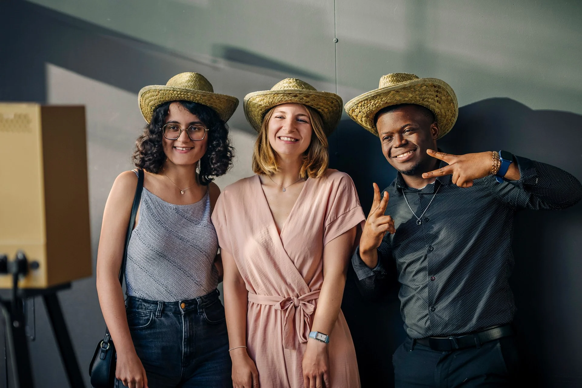 Groupe d’étudiants posant avec des chapeaux de paille devant le photobooth de la soirée CBH Graduate School à Grenoble.