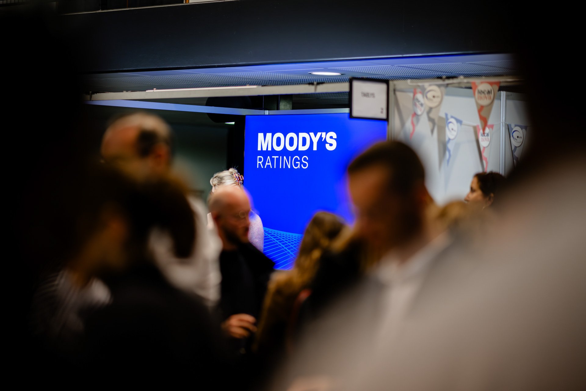 Détail des échanges conviviaux entre participants pendant les pauses café des Assises de l’AFIGESE 2024 devant le stand Moody's.