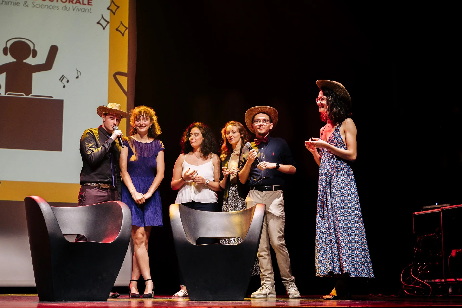 Groupe d’étudiants et organisateurs du programme CBH Graduate School sur scène, coiffés de chapeaux, lors de la remise des prix du gala UGA.