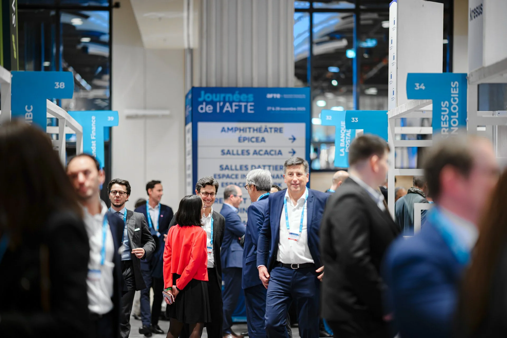 Circulation des participants dans l’espace du salon AFTE 2025, avec signalétique et zones de conférences au CNIT Forest Paris La Défense.