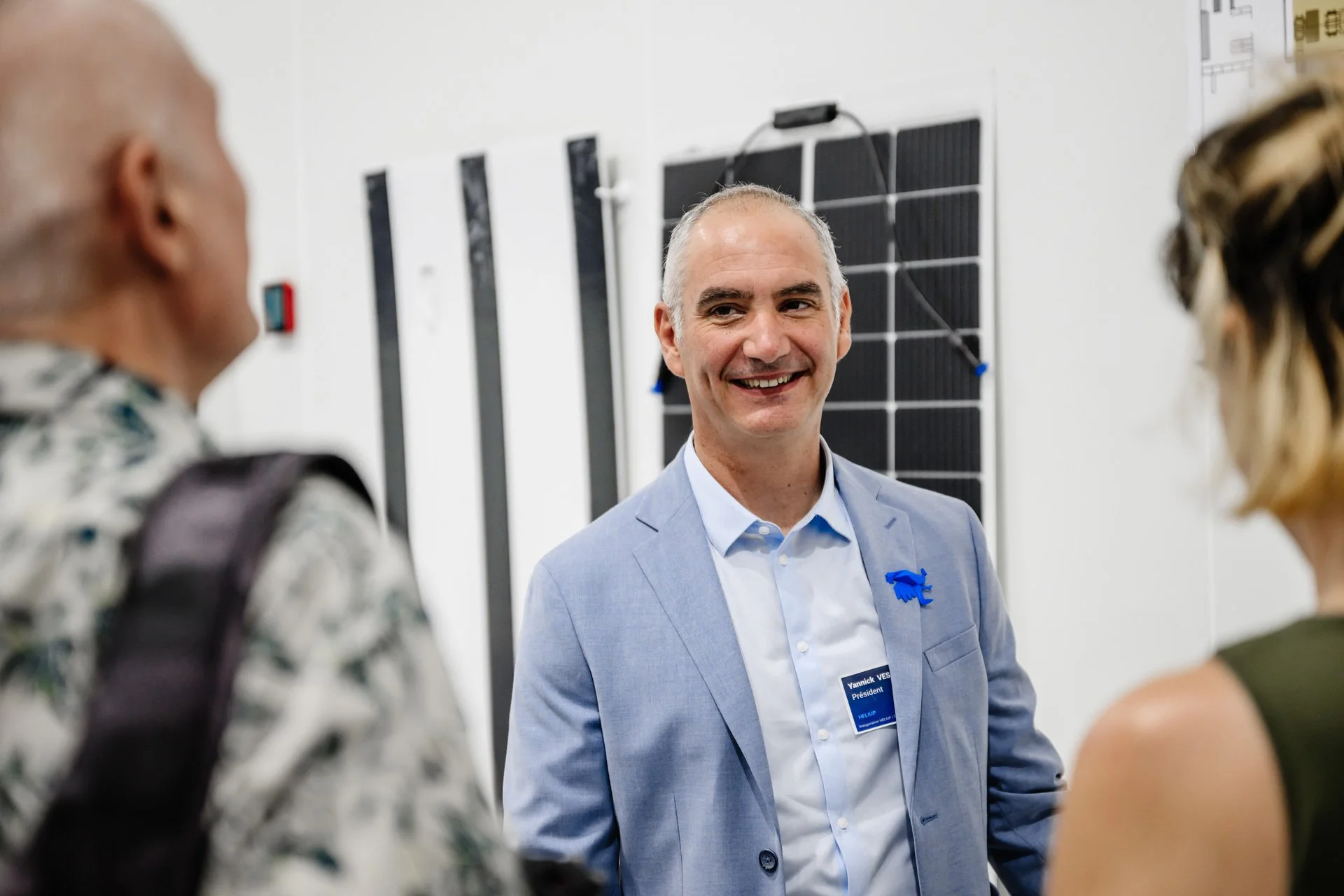 Yannick Veschetti échangeant avec des visiteurs devant les prototypes de panneaux solaires Heliup.