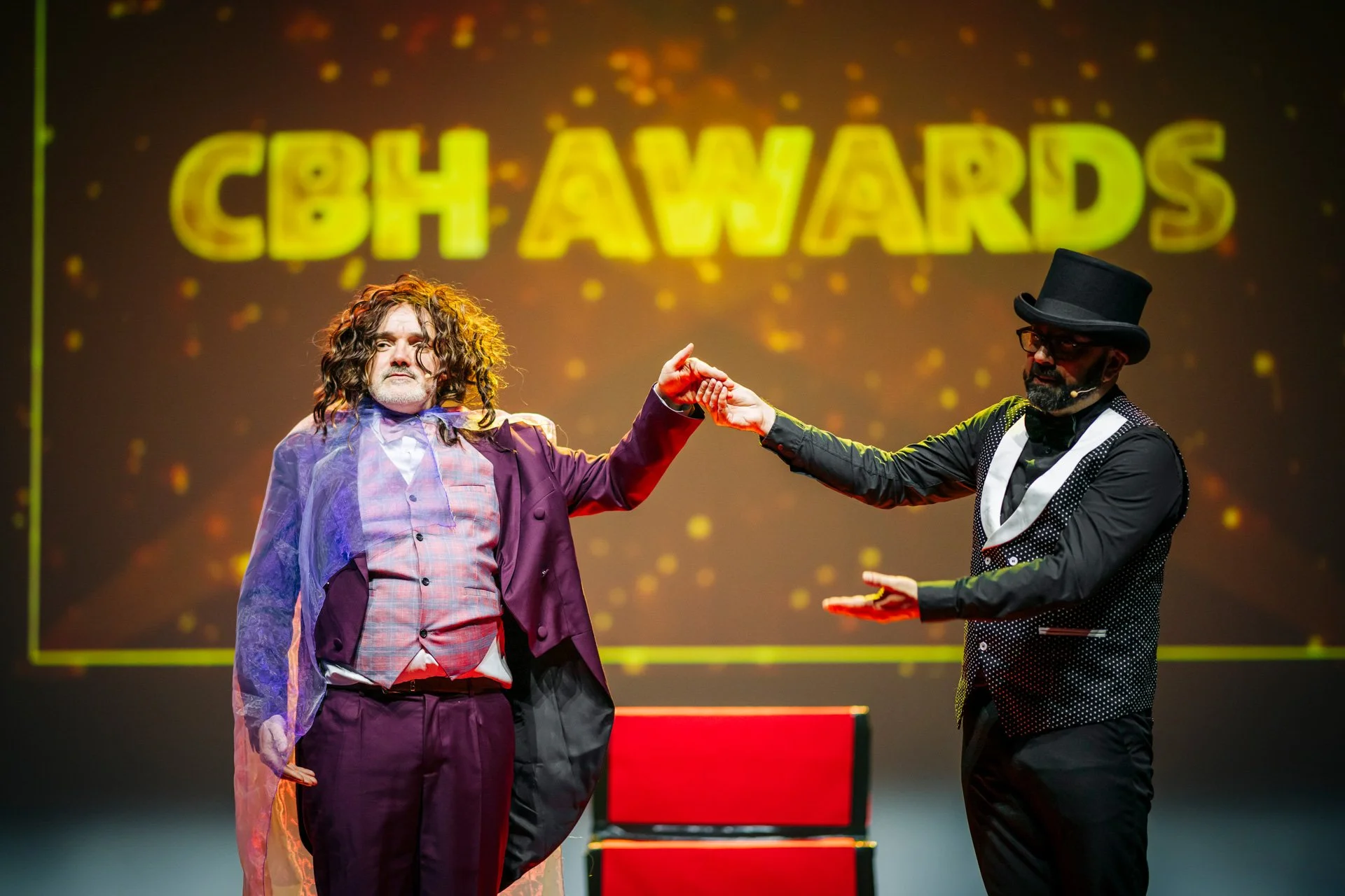 Deux maîtres de cérémonie déguisés pour les « CBH Awards » sur la scène du gala CBH Graduate School à la Belle Électrique.