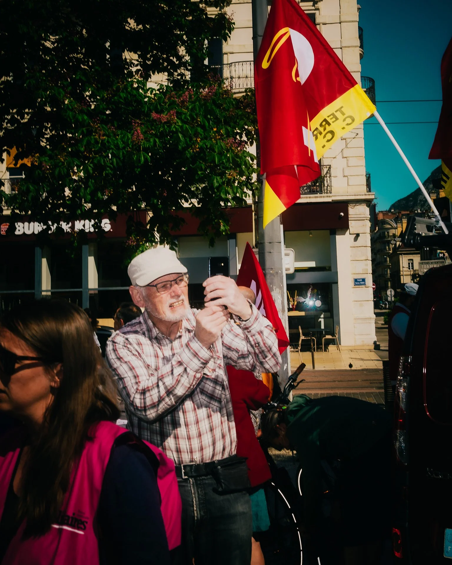 Portrait d’un enseignant dans la foule pendant la mobilisation du 5 mai 2025 à Grenoble – photographie de rue au flash.