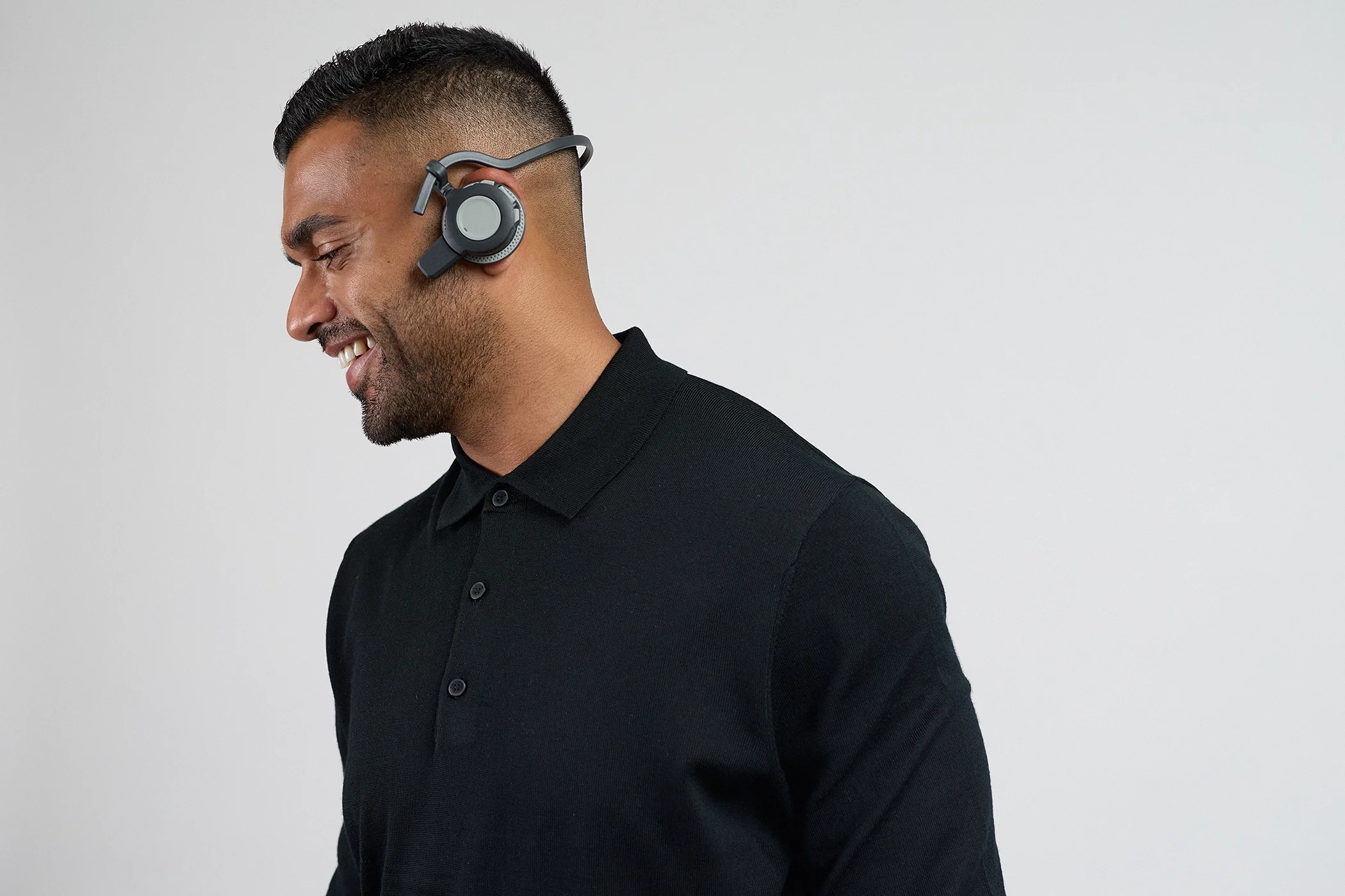 Professional studio portrait of a model wearing a headset against a seamless white background, illuminated with clean high-key lighting.