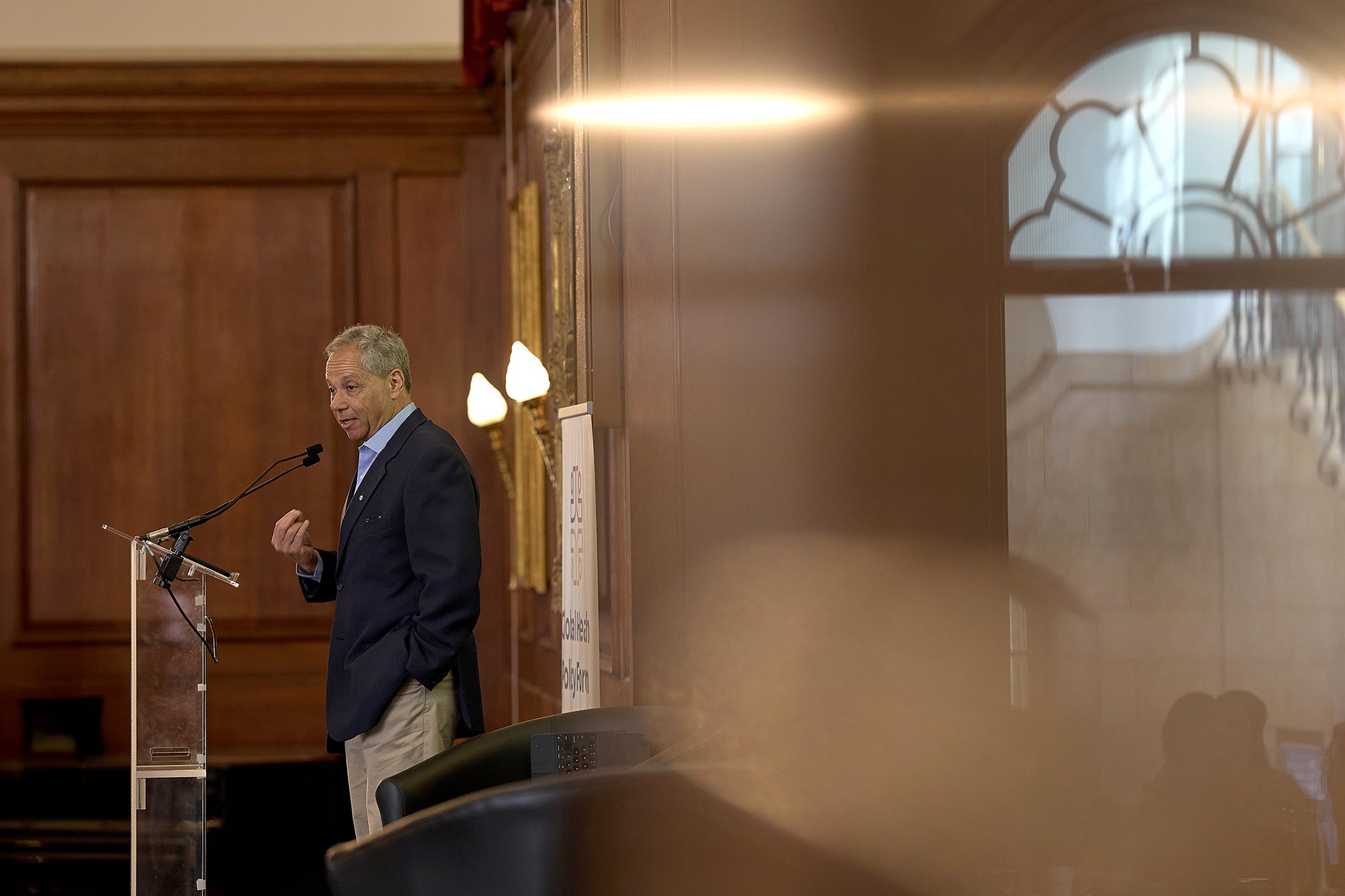 Dr. Peter Singer, global health expert and former WHO Special Advisor, delivering a keynote address at the IHP PQMD summit in London, captured by Matt Ankers Studio.