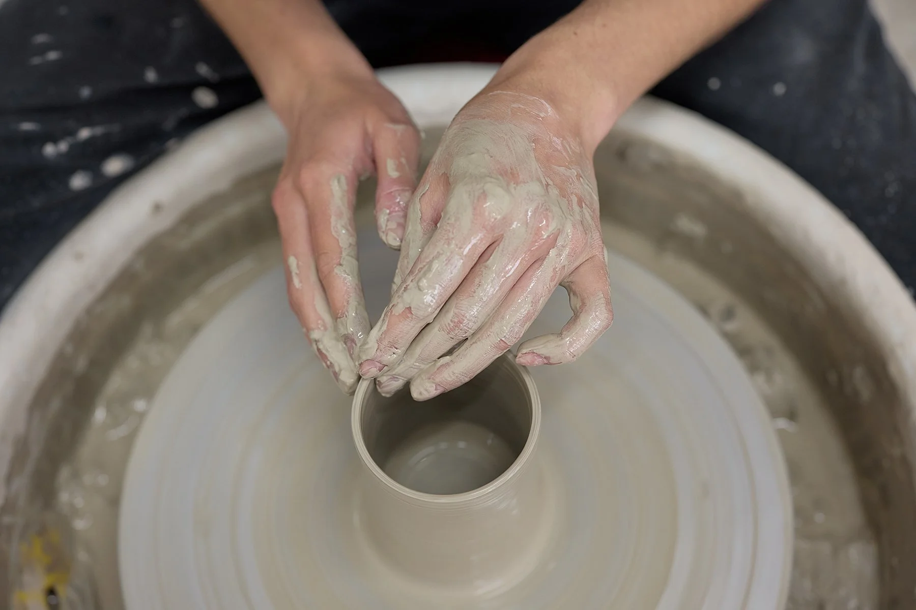 Close-up black and white photography of potter Kitty Ward's hands shaping clay in her Cornwall studio for a commercial artisan branding campaign.