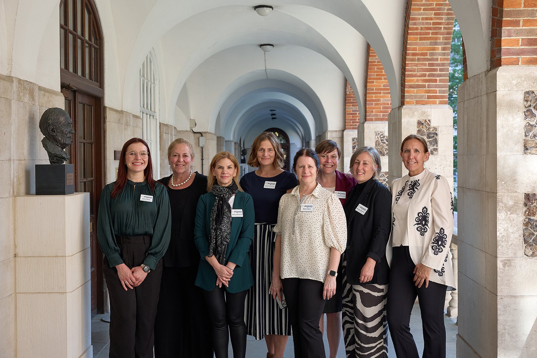 Professional business group portrait of PQMD delegates at Goodenough House, London, showcasing a multi-sectoral team during the World Health Summit partnership event.