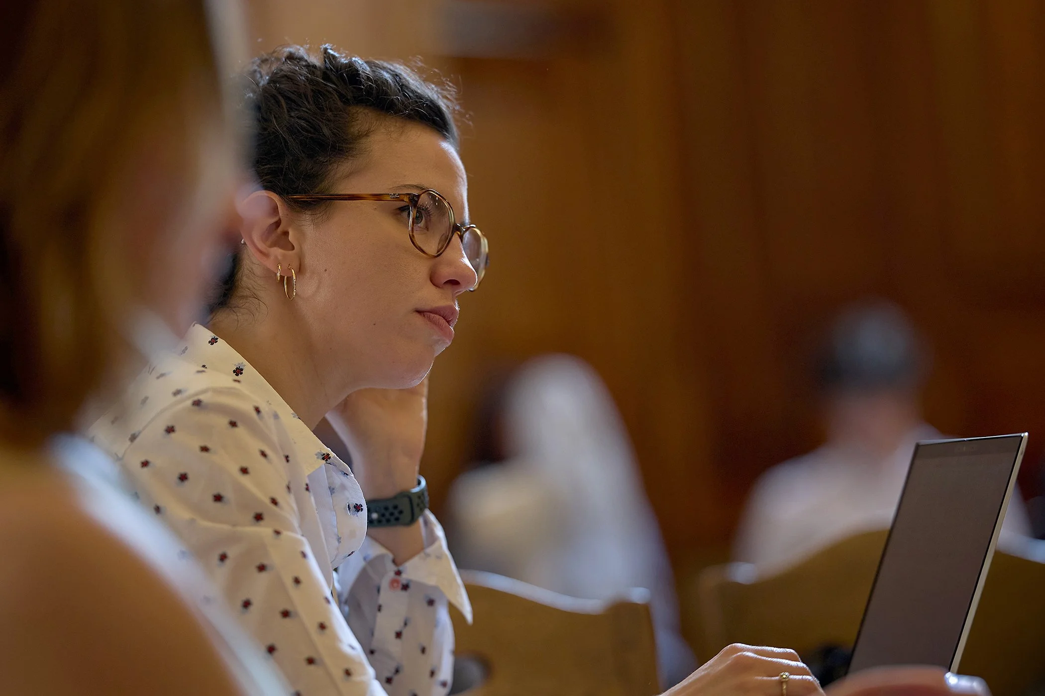 Candid photography of audience engagement at a London health conference, capturing a woman making notes for digital PR and authentic event storytelling.