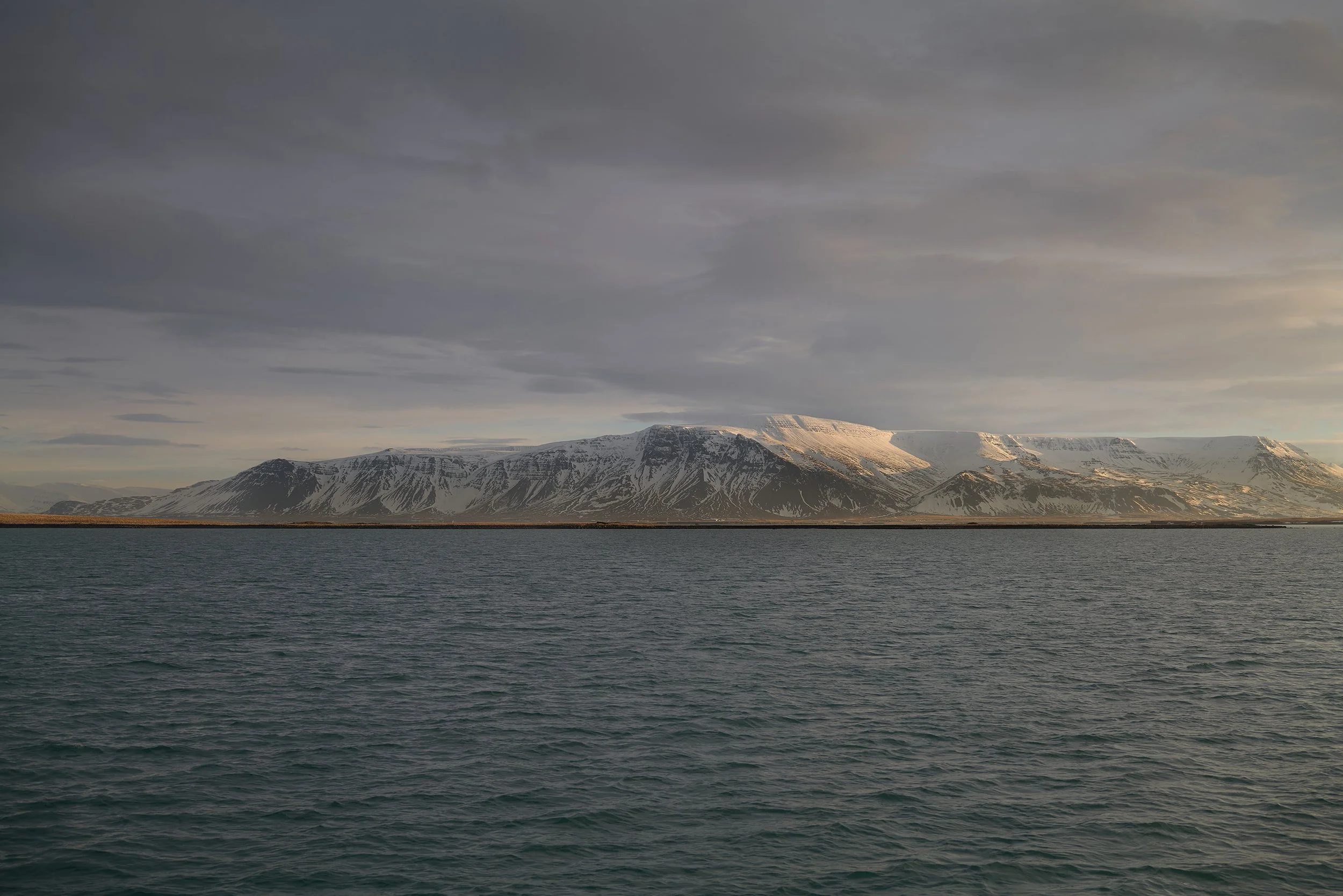 Dramatic Icelandic coastal landscape photography, documenting the authentic, harsh terrain around Reykjavik for high-end travel branding and storytelling.