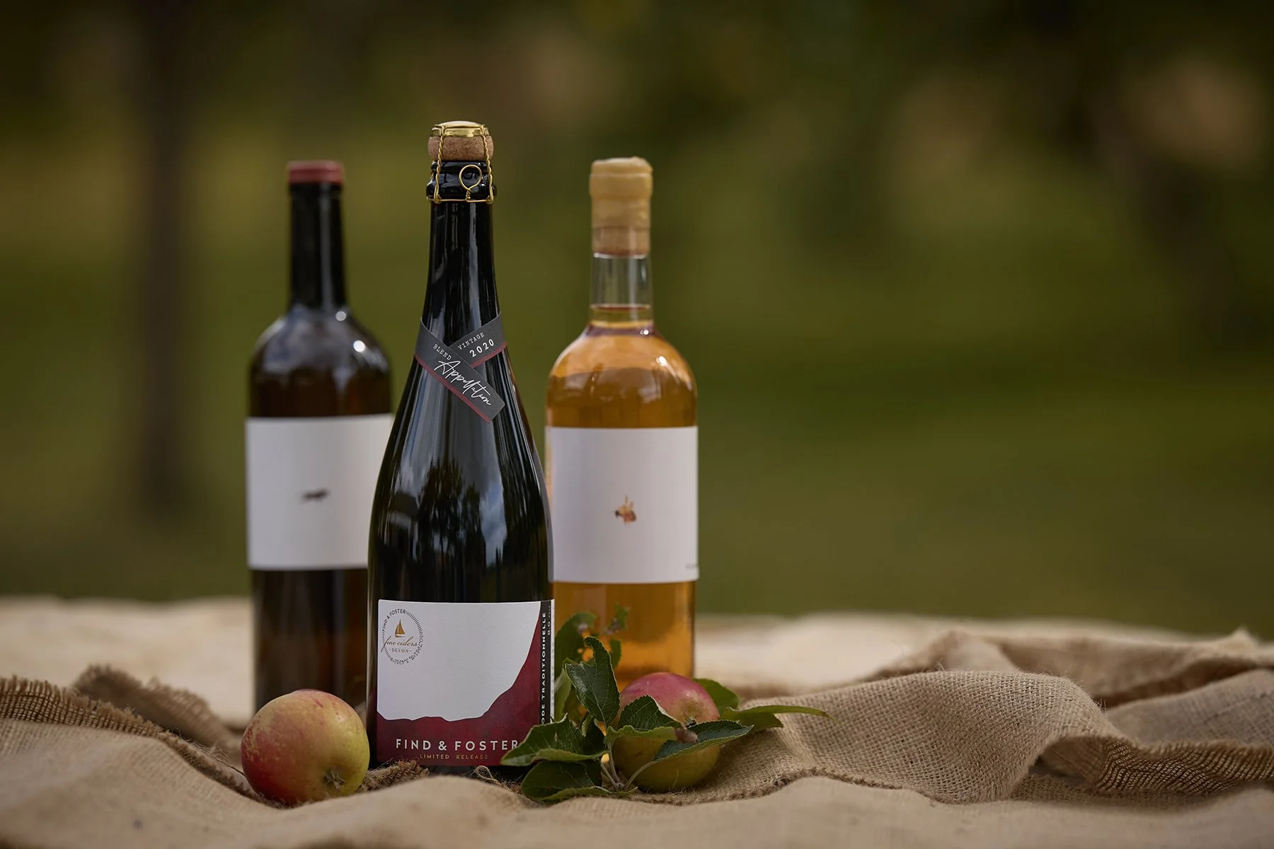 The full collection of Find & Foster fine cider bottles styled in the traditional Devon orchard where the apples are grown.