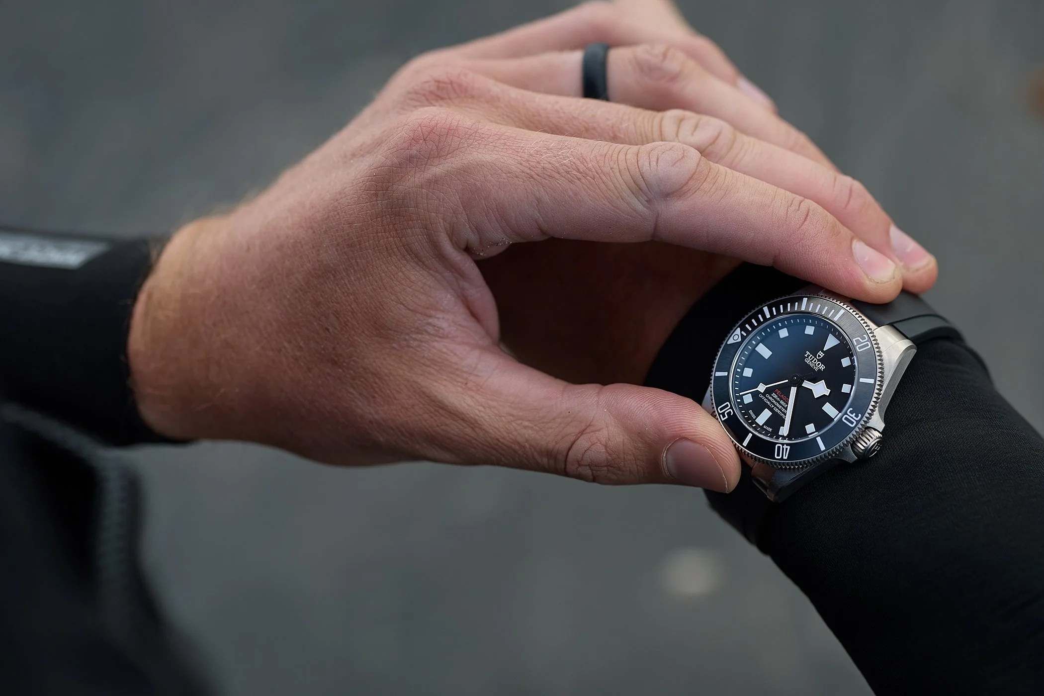 Commercial product photography on East Wittering beach, capturing a close-up of a Tudor Pelagos 39 dive watch and O'Neill wetsuit for luxury lifestyle advertising campaigns.