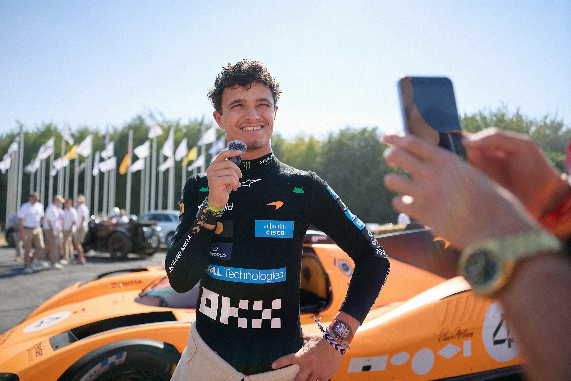 Lando Norris being interviewed alongside his McLaren Formula 1 car at the 2026 Goodwood Festival of Speed.