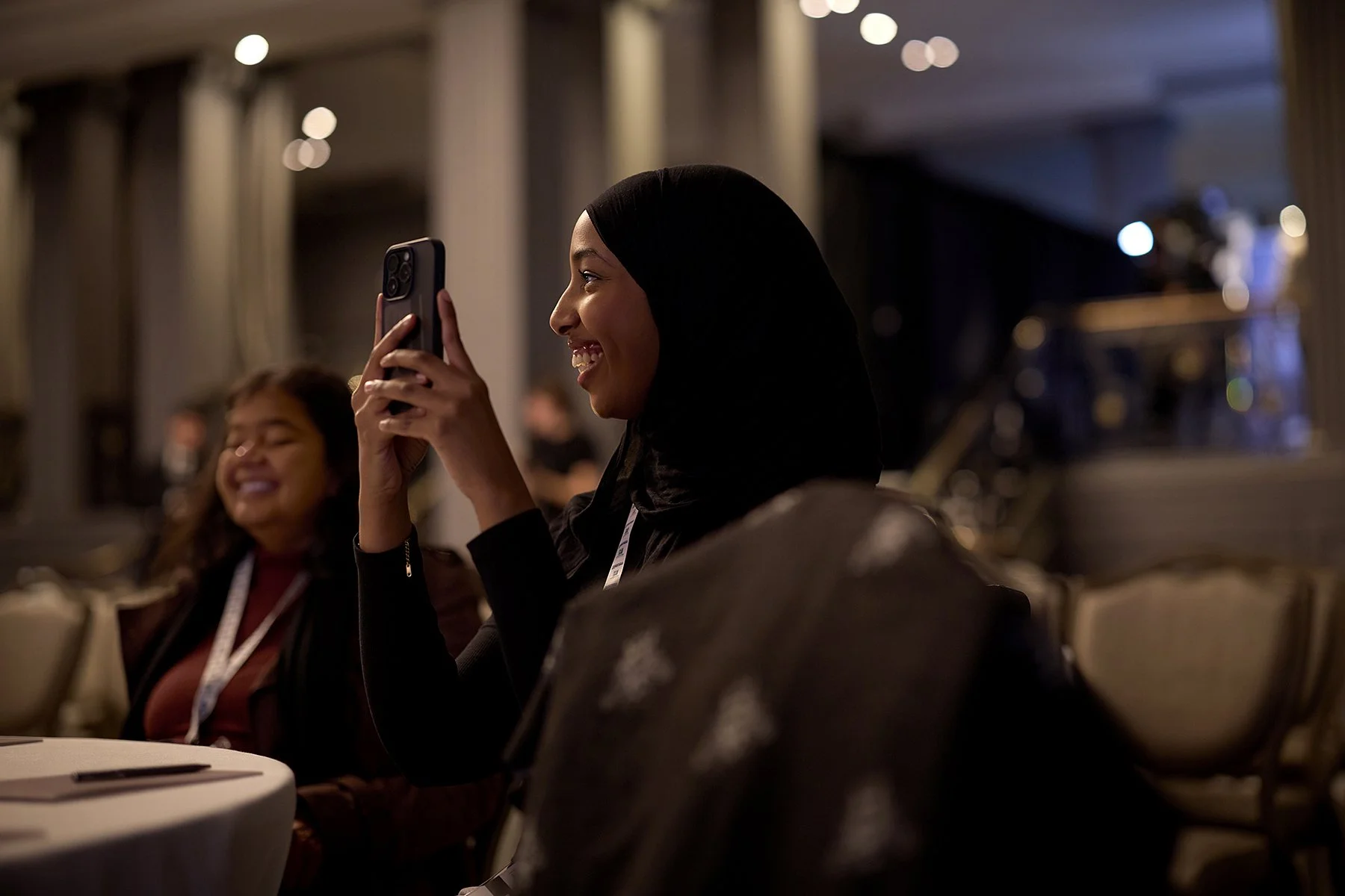 Candid photography of an attendee interacting with the Al Baraka Summit location in London, capturing event experience for authentic social media and marketing assets.