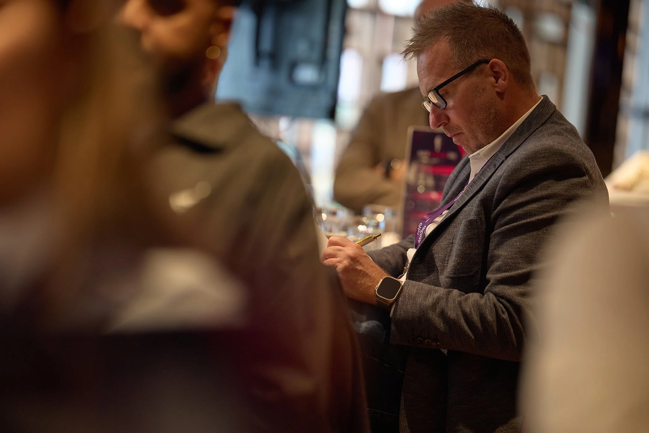 Candid photography of a professional note-taker working at the VoCoVo London event, capturing focused corporate engagement and event documentation services.
