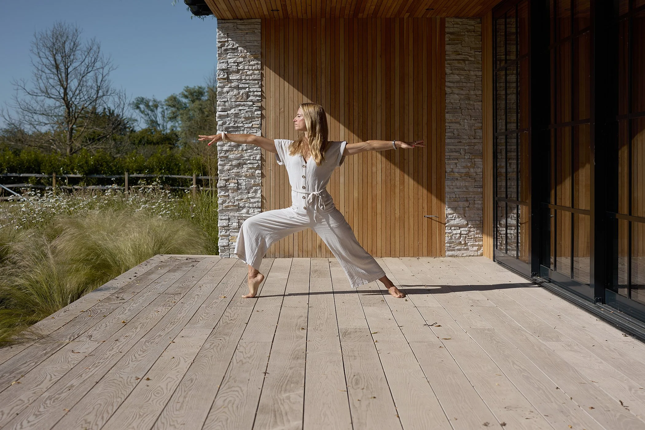 Environmental portrait of Wild Willow founder Rachael Richards practicing yoga and breathwork at her Chichester studio for authentic wellness branding.