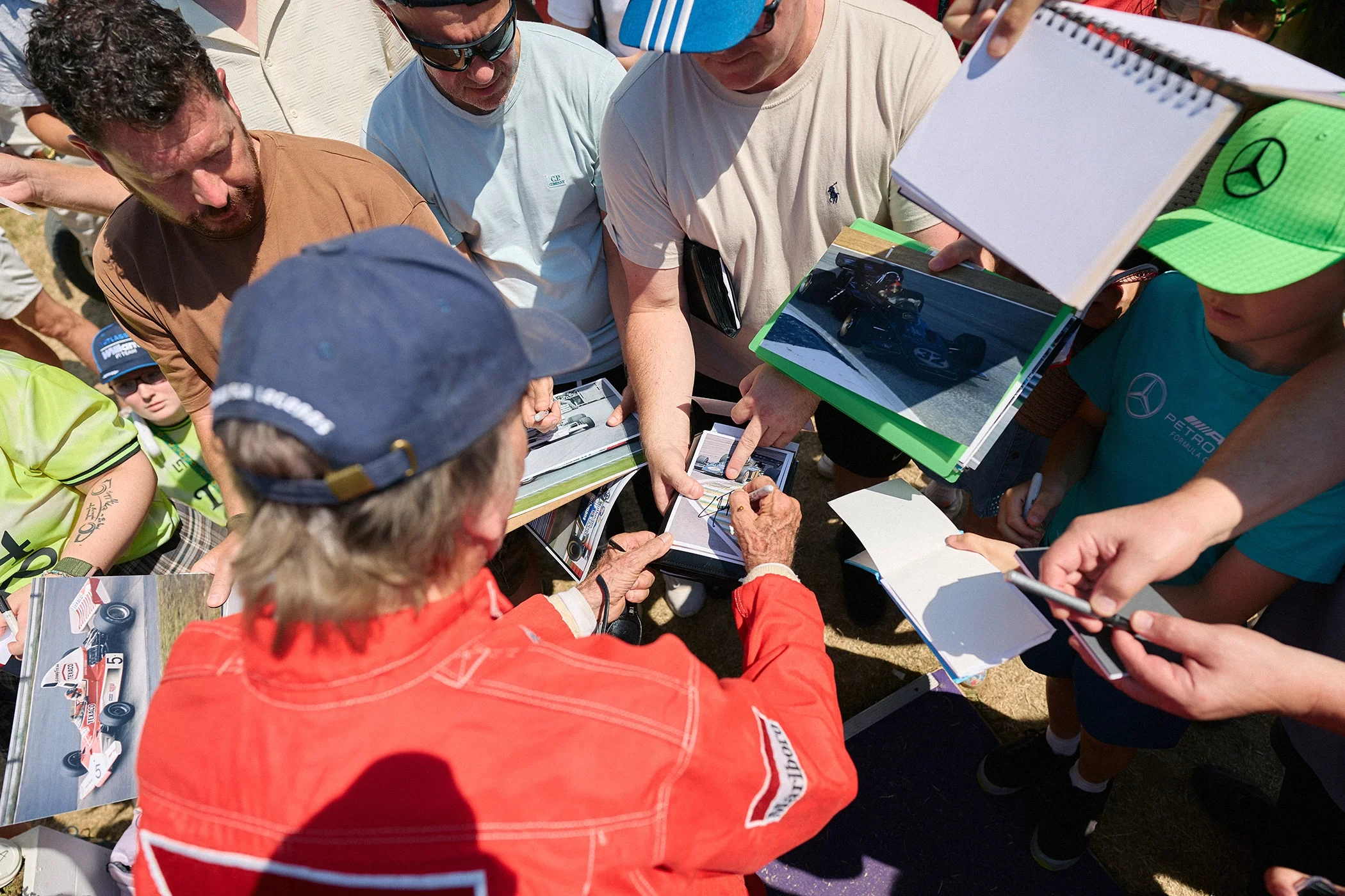 Two-time Formula 1 World Champion Emerson Fittipaldi signing autographs for fans at the 2026 Goodwood Festival of Speed.