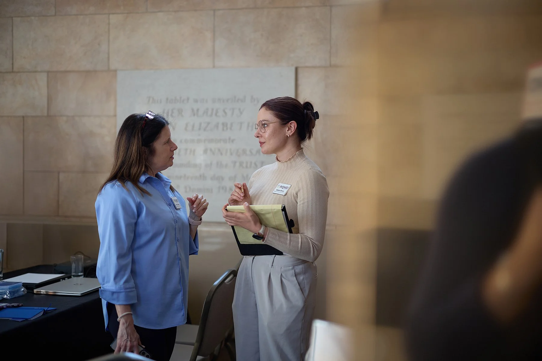 Candid photography of Sherri Huffman, Senior Director of Global Programs, and Rylee Glick, Director of Communications at PQMD, planning during the London Global Health Forum.