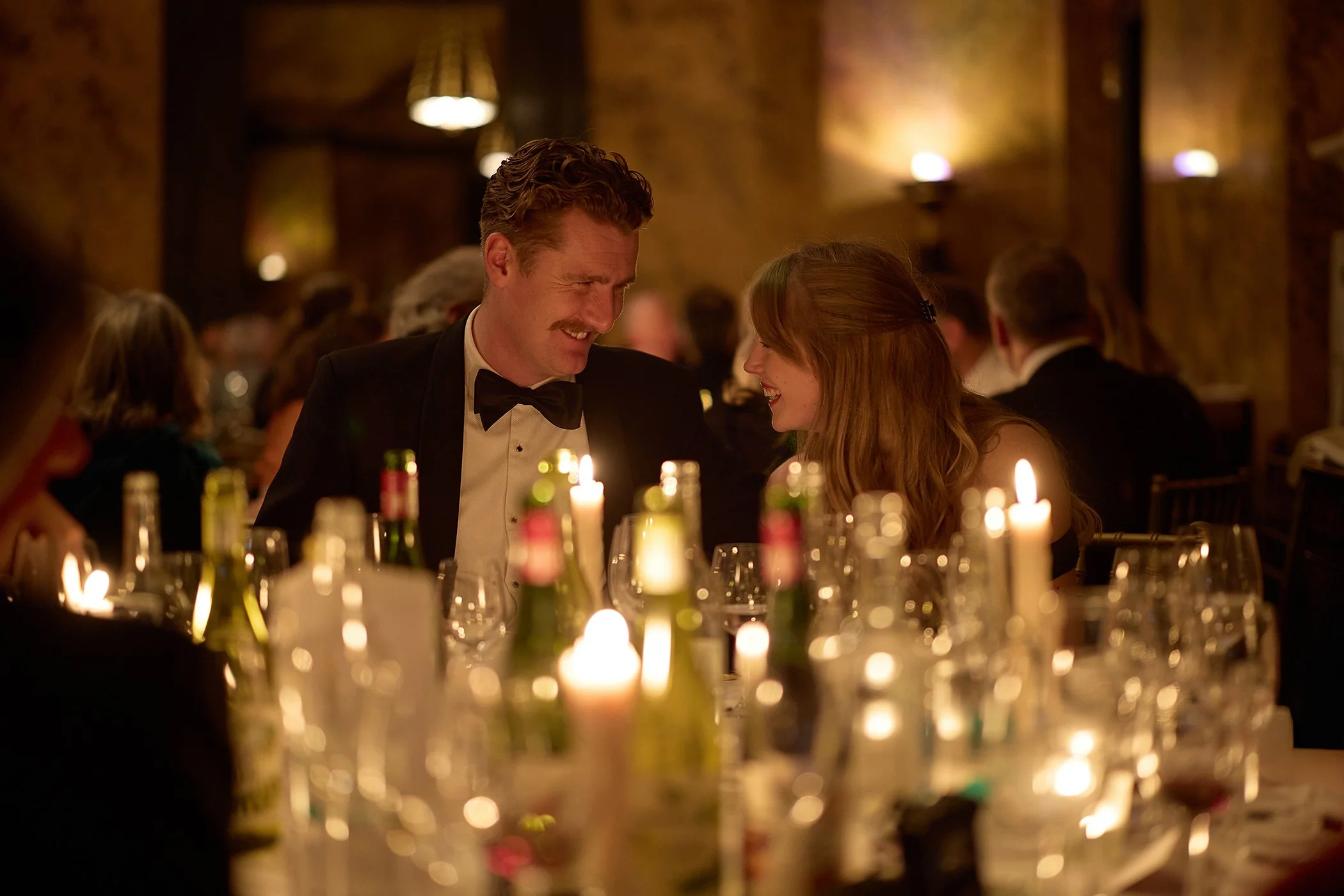 Authentic lifestyle photography of a young couple laughing at the Goodwood GRRC Ball, capturing a candid, human moment for luxury event branding and marketing assets.