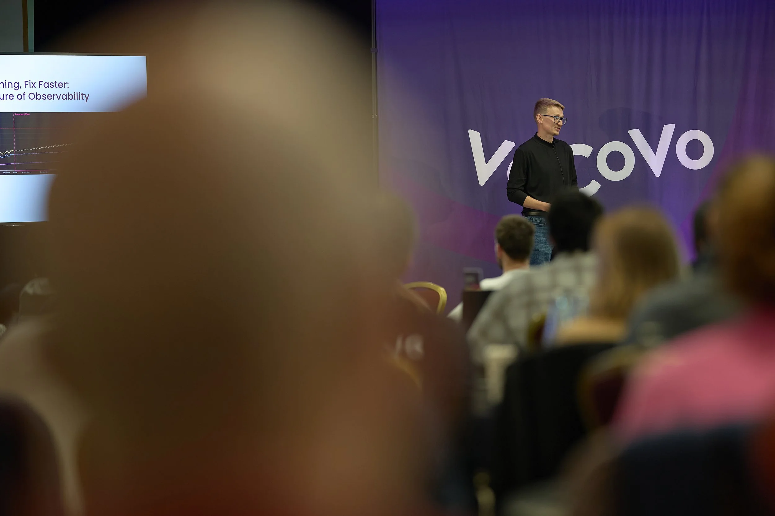 A wide-angle perspective of a keynote speaker delivering a presentation during the VoCoVo corporate summit in Oxford.