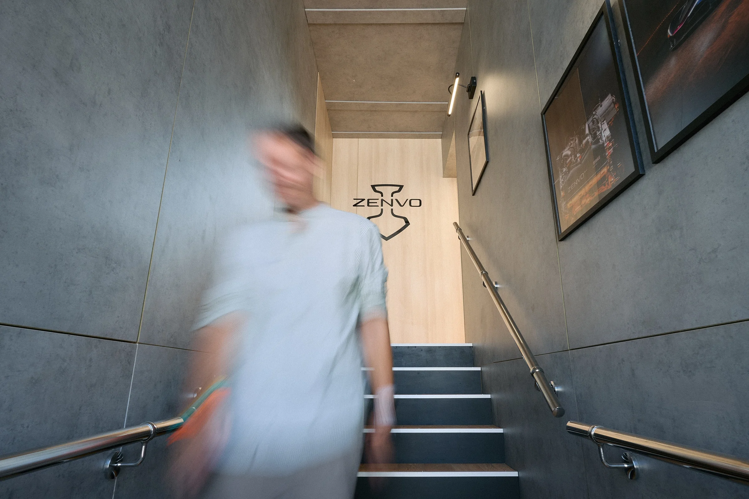 Motion-blurred visitor walking through the Zenvo Automotive stand at the 2026 Goodwood Festival of Speed.