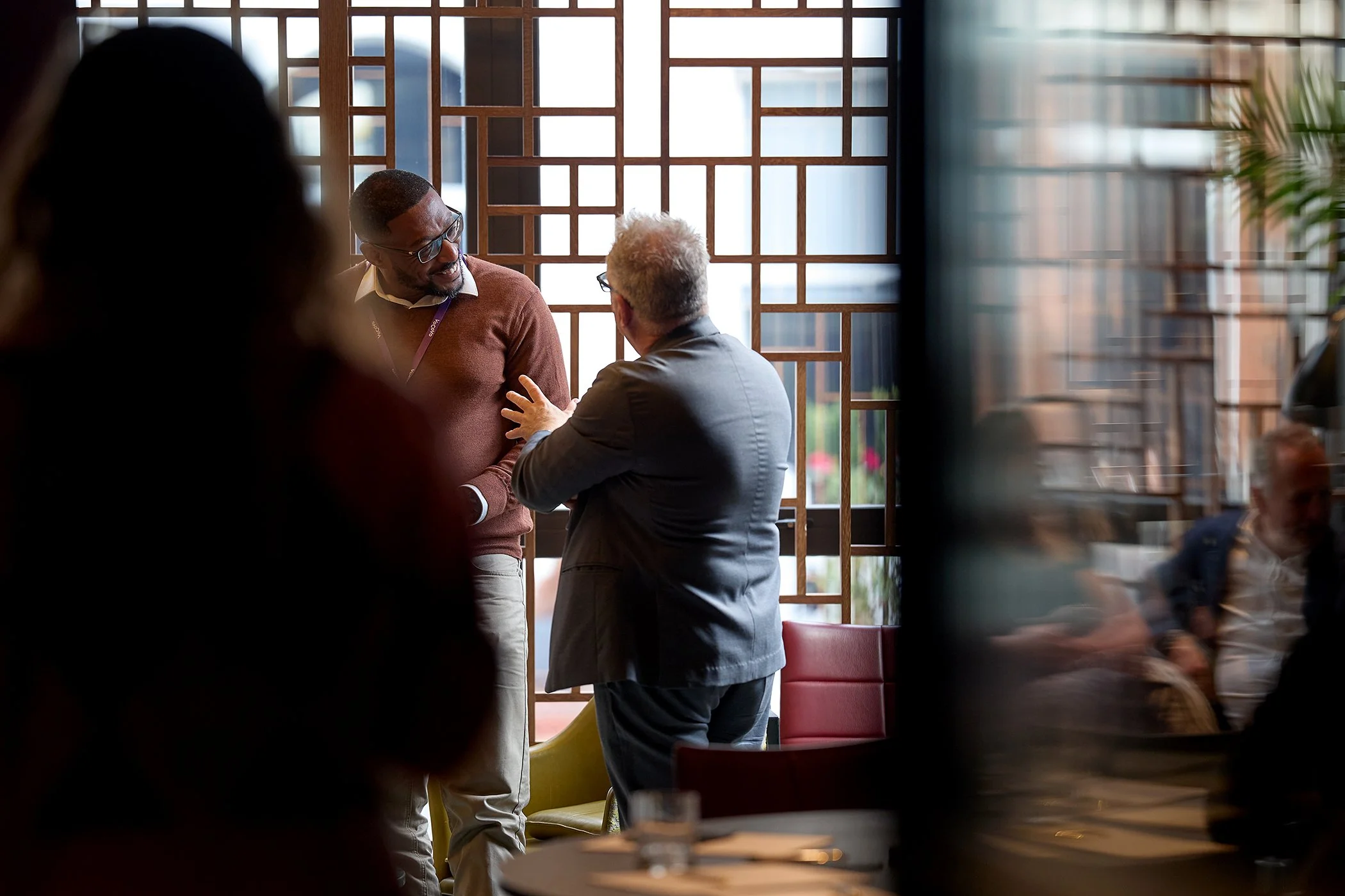 Unobtrusive **corporate** event photography in London, featuring delegates engaged in casual **business** discussion at the **VoCoVo** innovation forum.