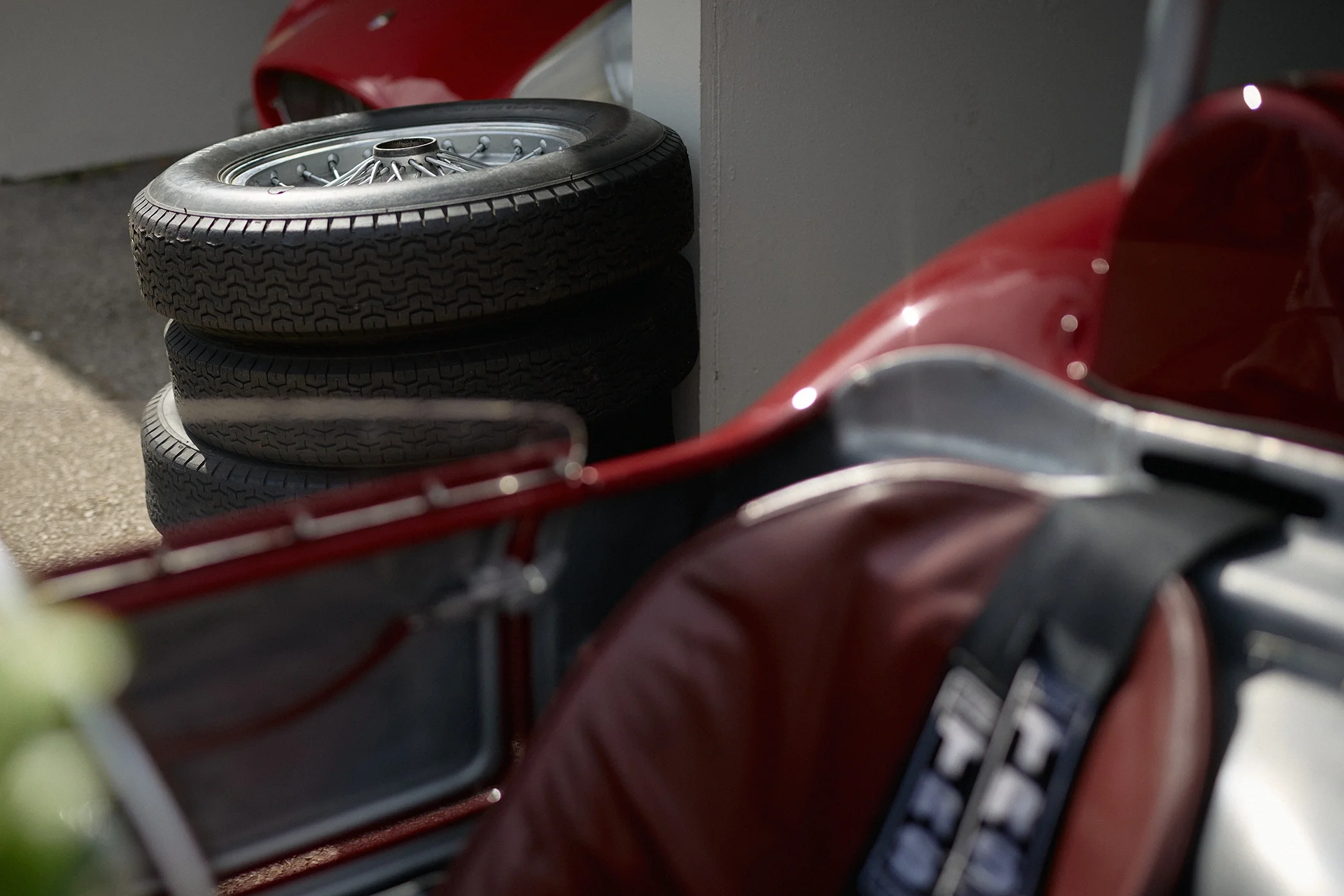 Vintage Ferrari racing car with stacked Dunlop Racing tyres behind it at Goodwood Revival 2026