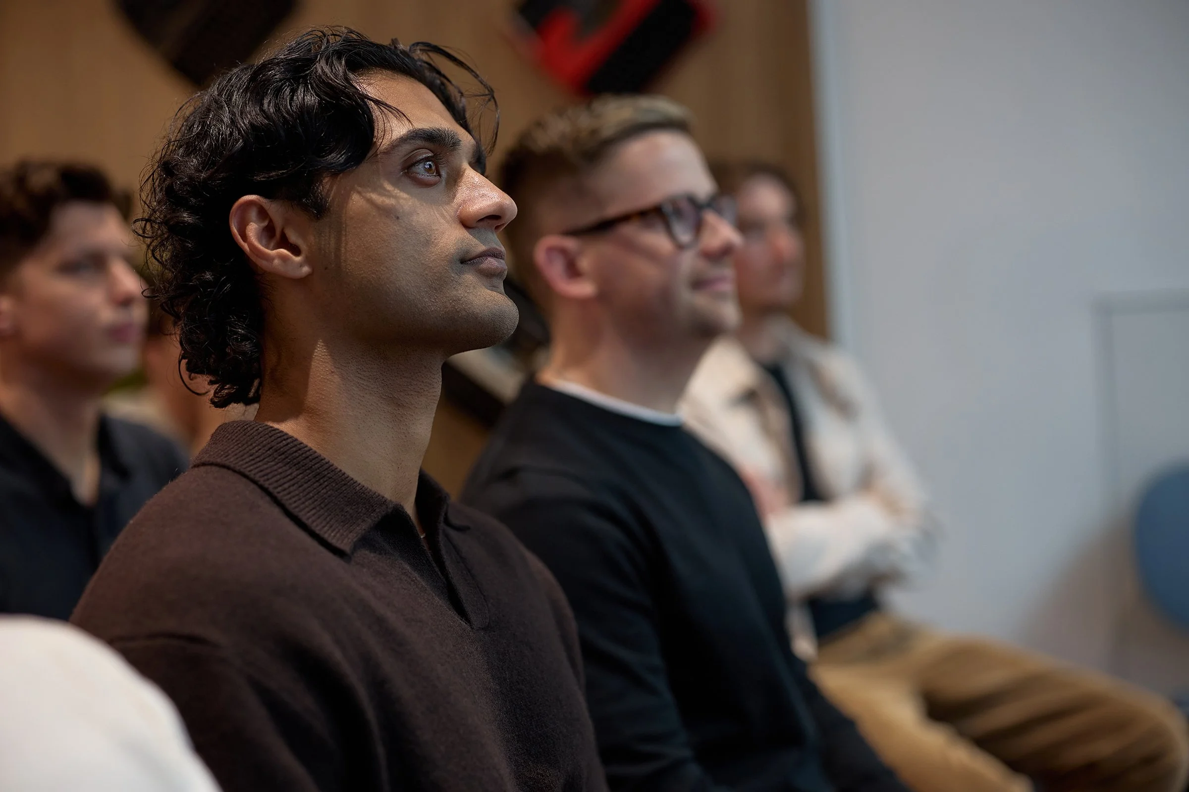 Candid photography of an attentive audience at a London corporate event, documenting the genuine energy and narrative of the &above tech conference.