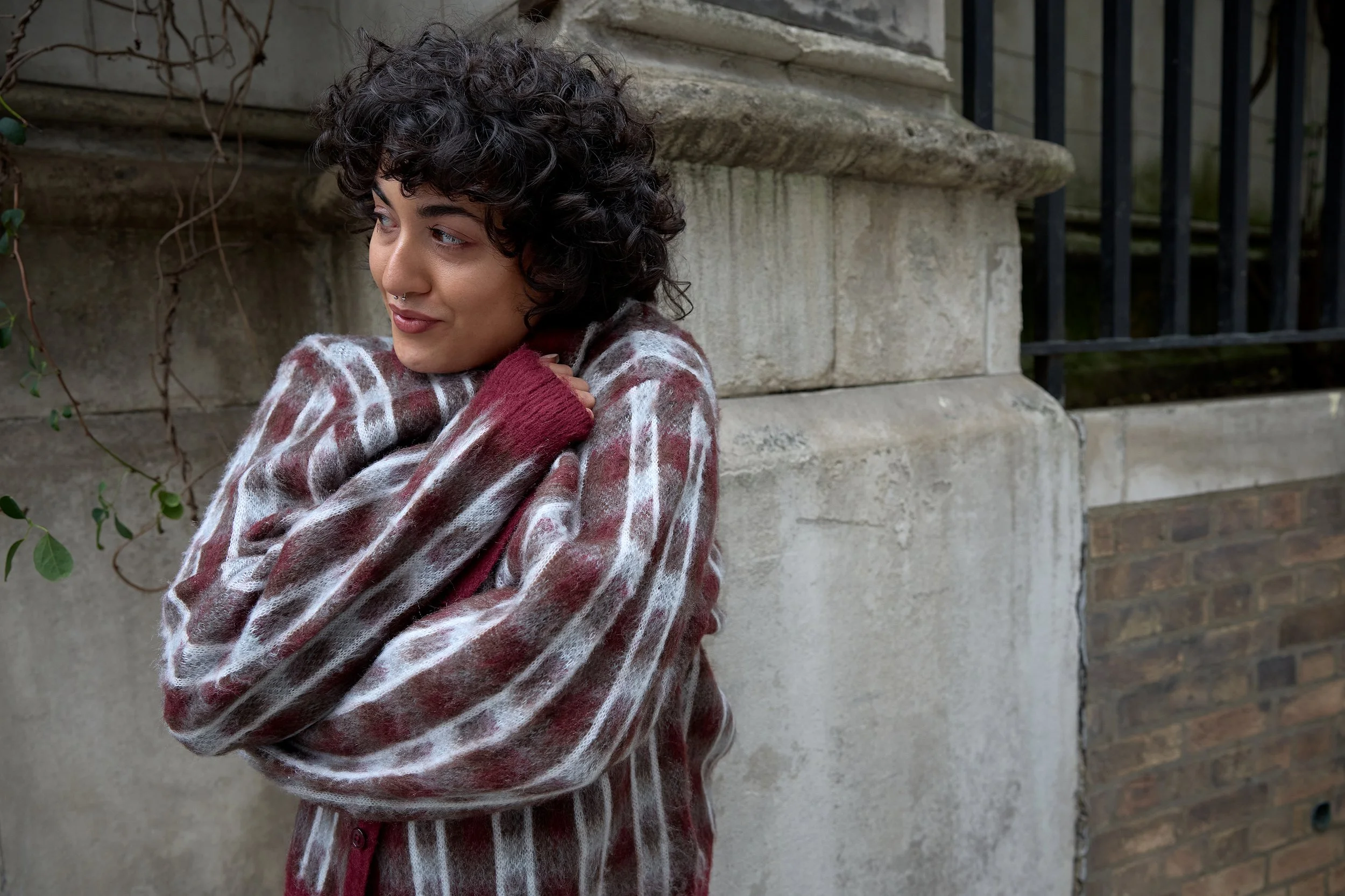 Commercial fashion photography near the Tower of London, capturing a woman modelling a knit jumper for a brand's e-commerce campaign in the city.
