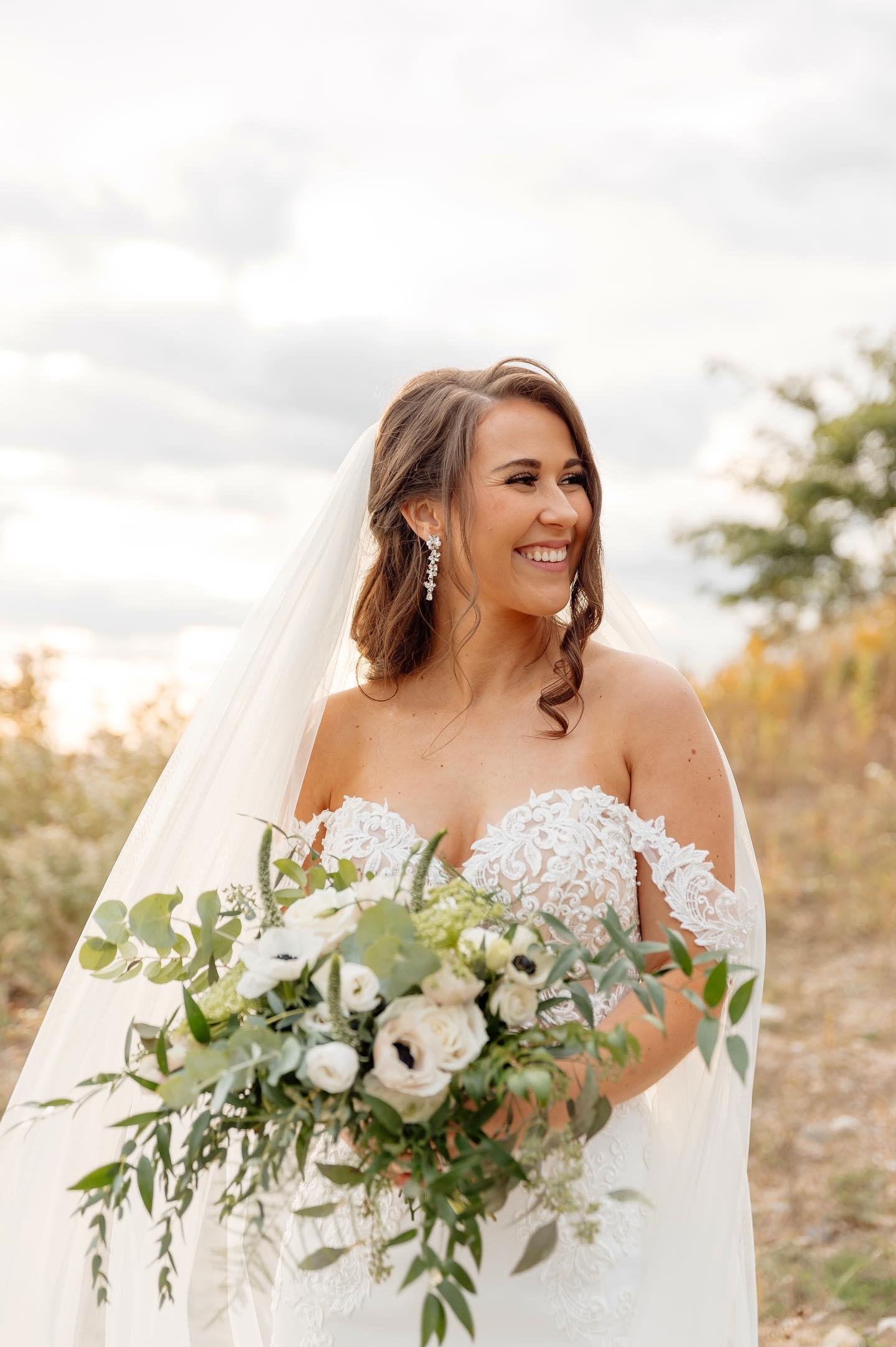 Happy bride holding her white flower bouquet