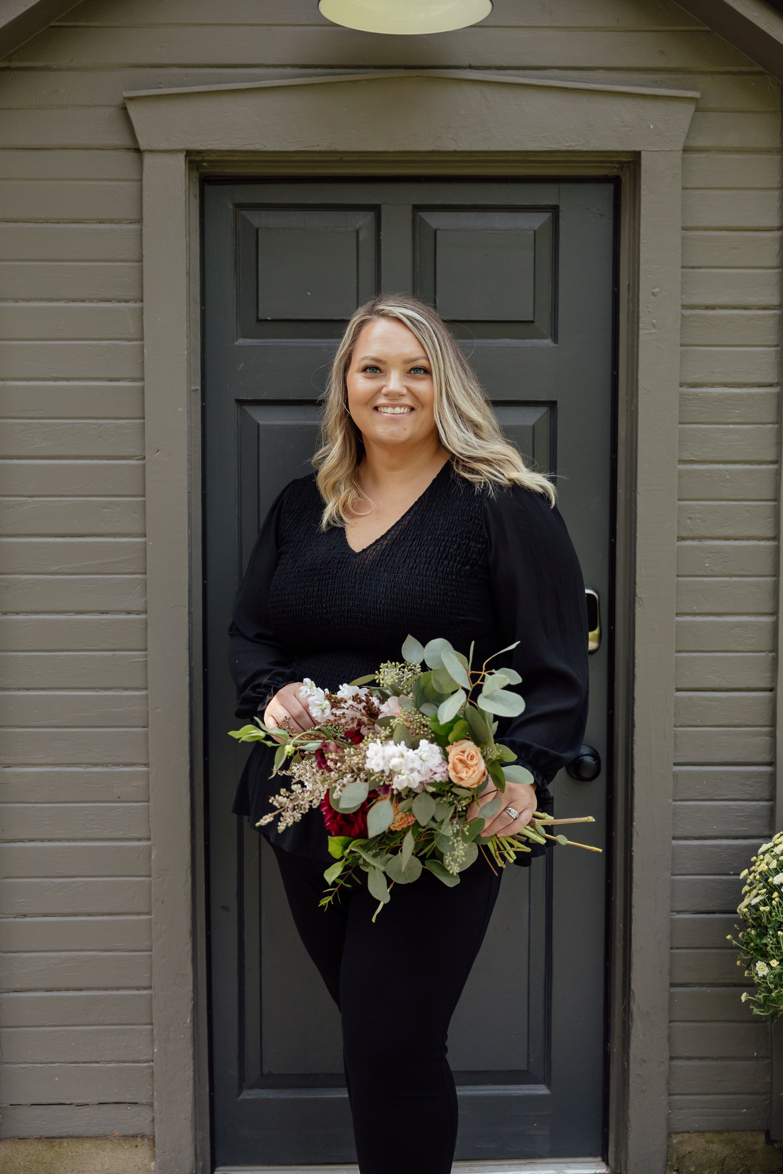Katlin Sumner holding a bouquet at the door front