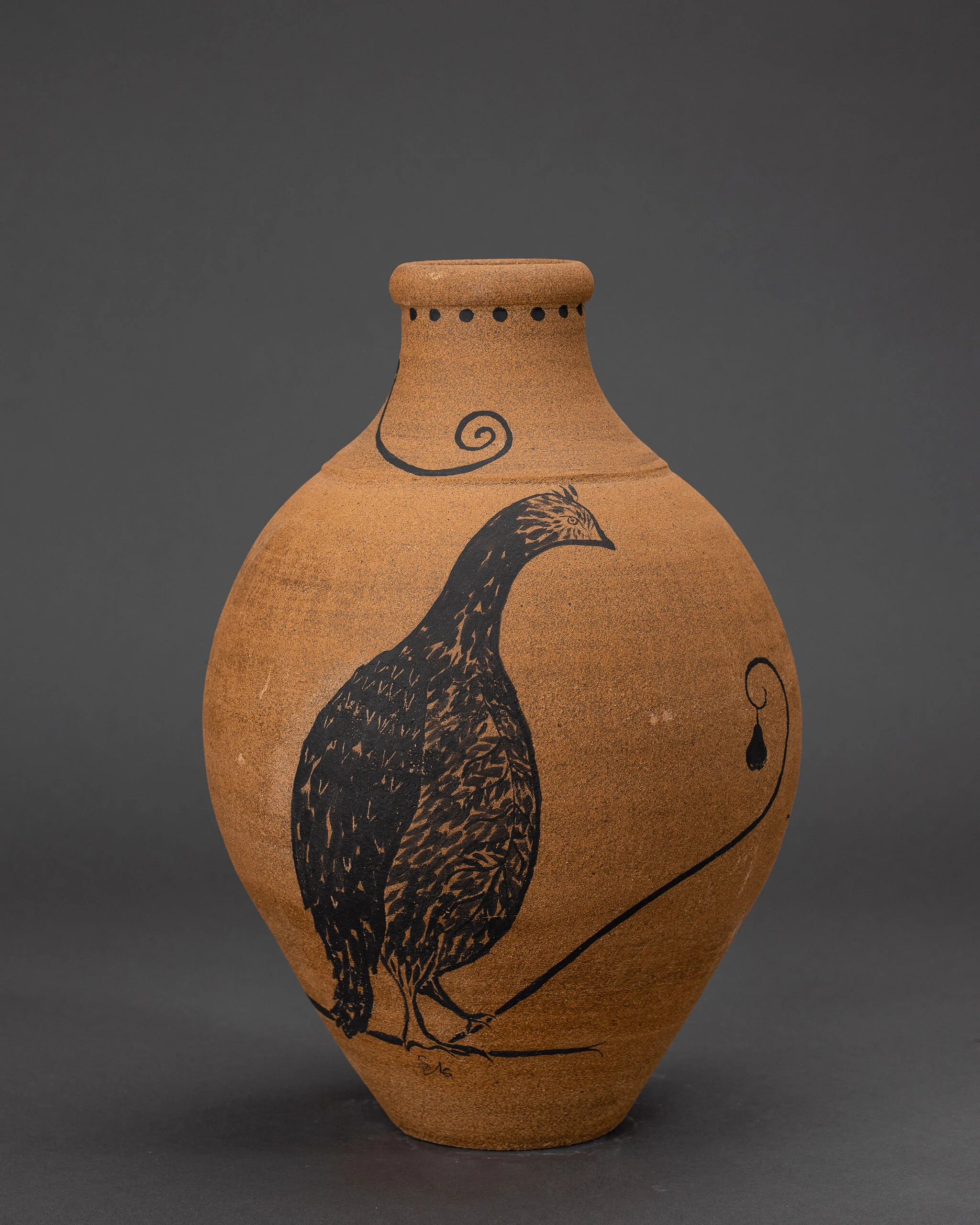 Brown clay vase painted with stylized black bird design