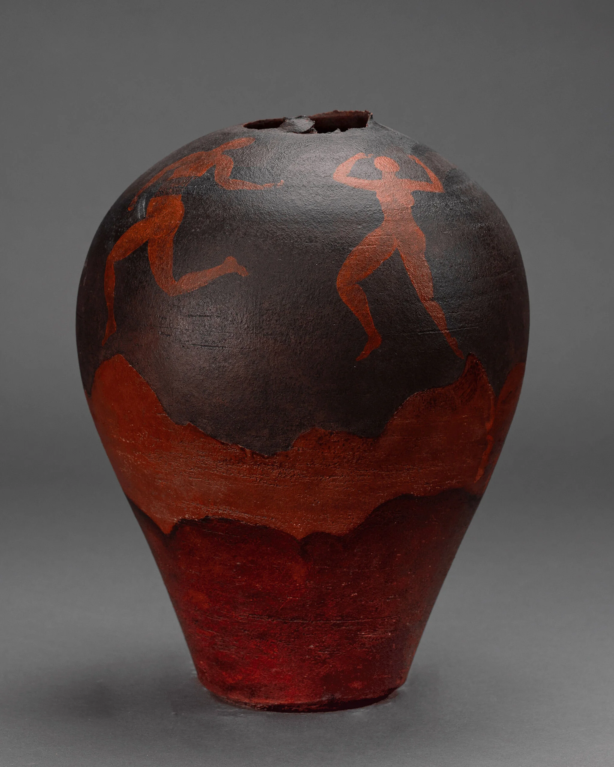 Red-and-black pottery vase with bold abstract patterned surface