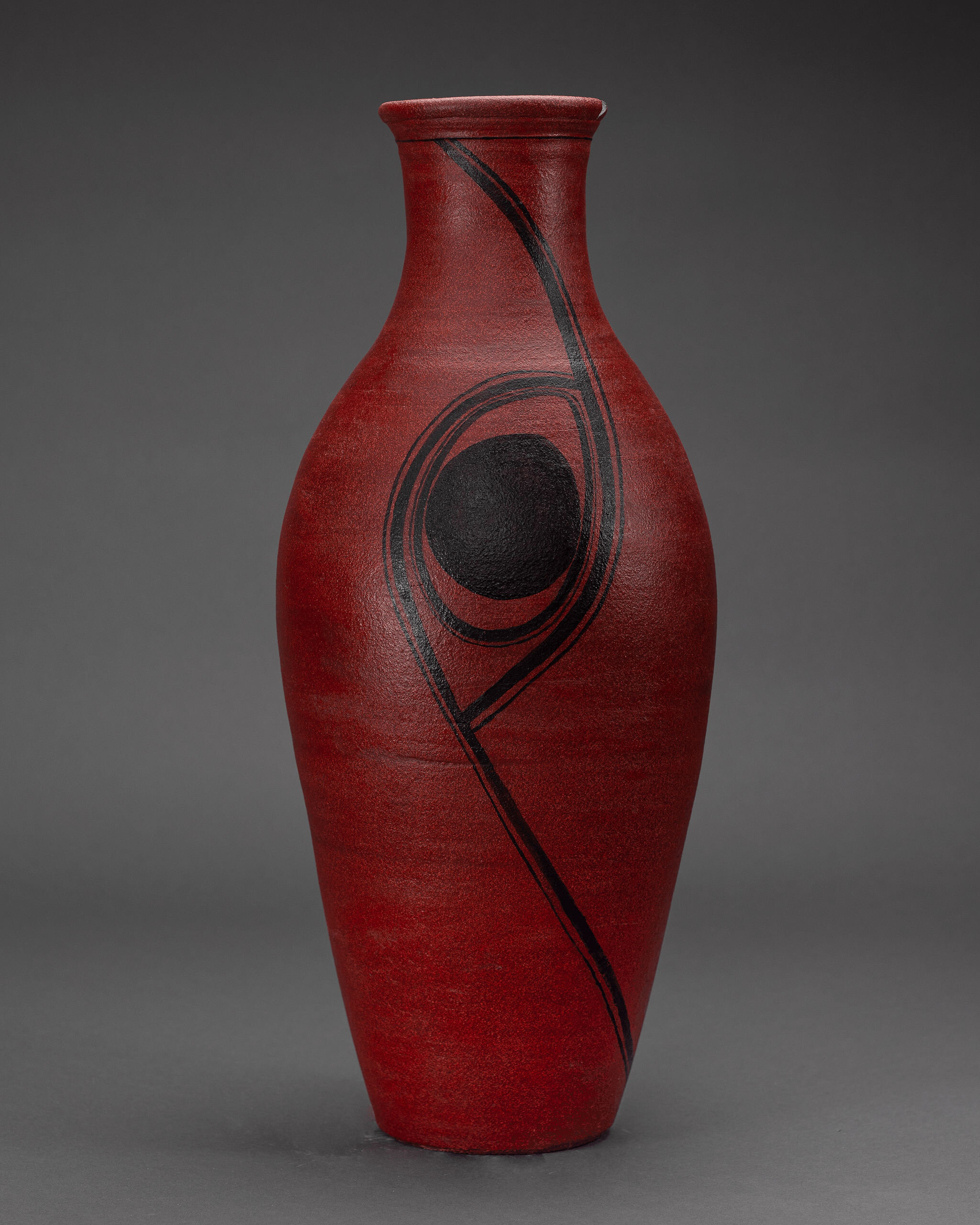 Tall red vase with striking black abstract design